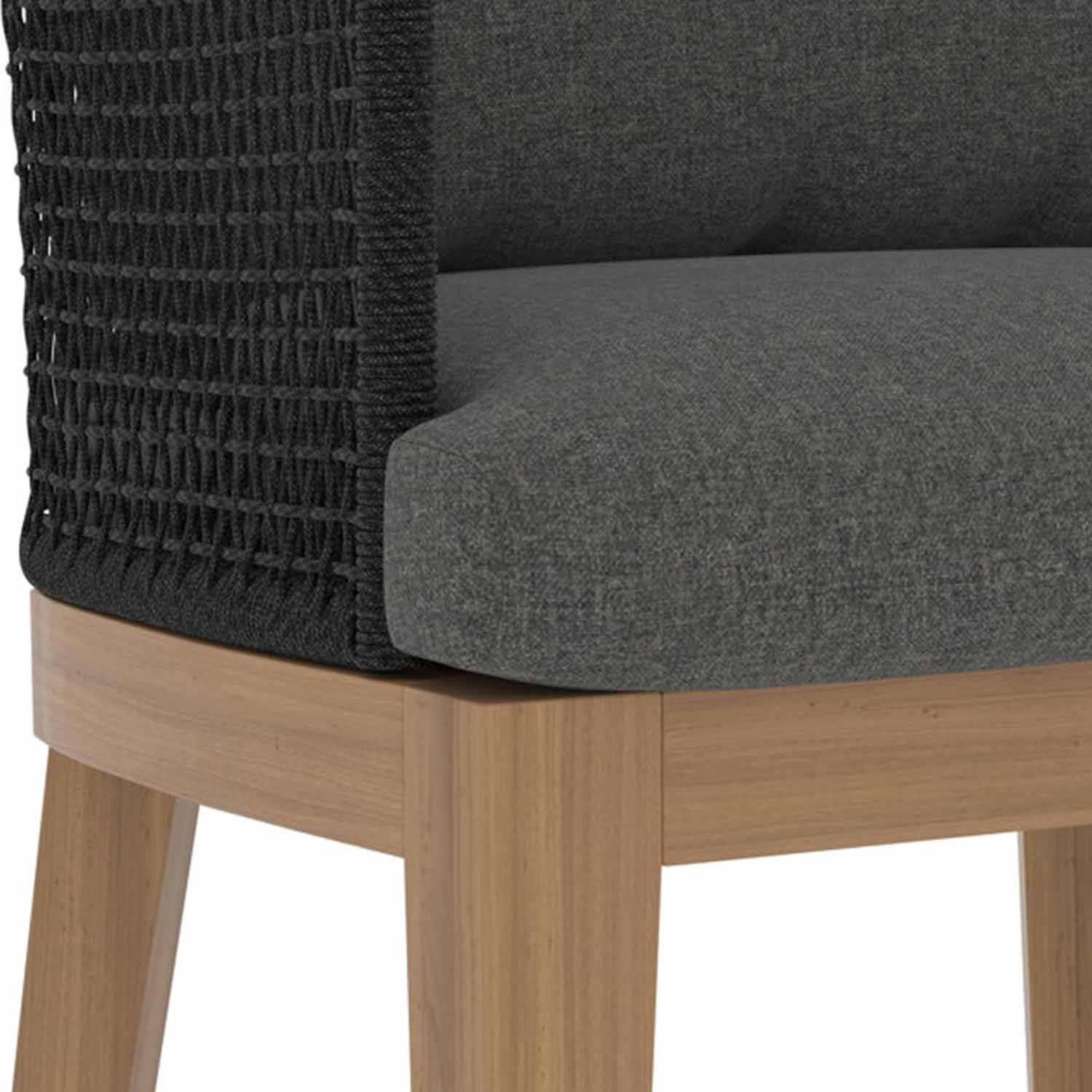 Close-up of an outdoor bar stool showing a teak wood base and legs, charcoal gray upholstered seat cushion, and woven dark rope back detail.