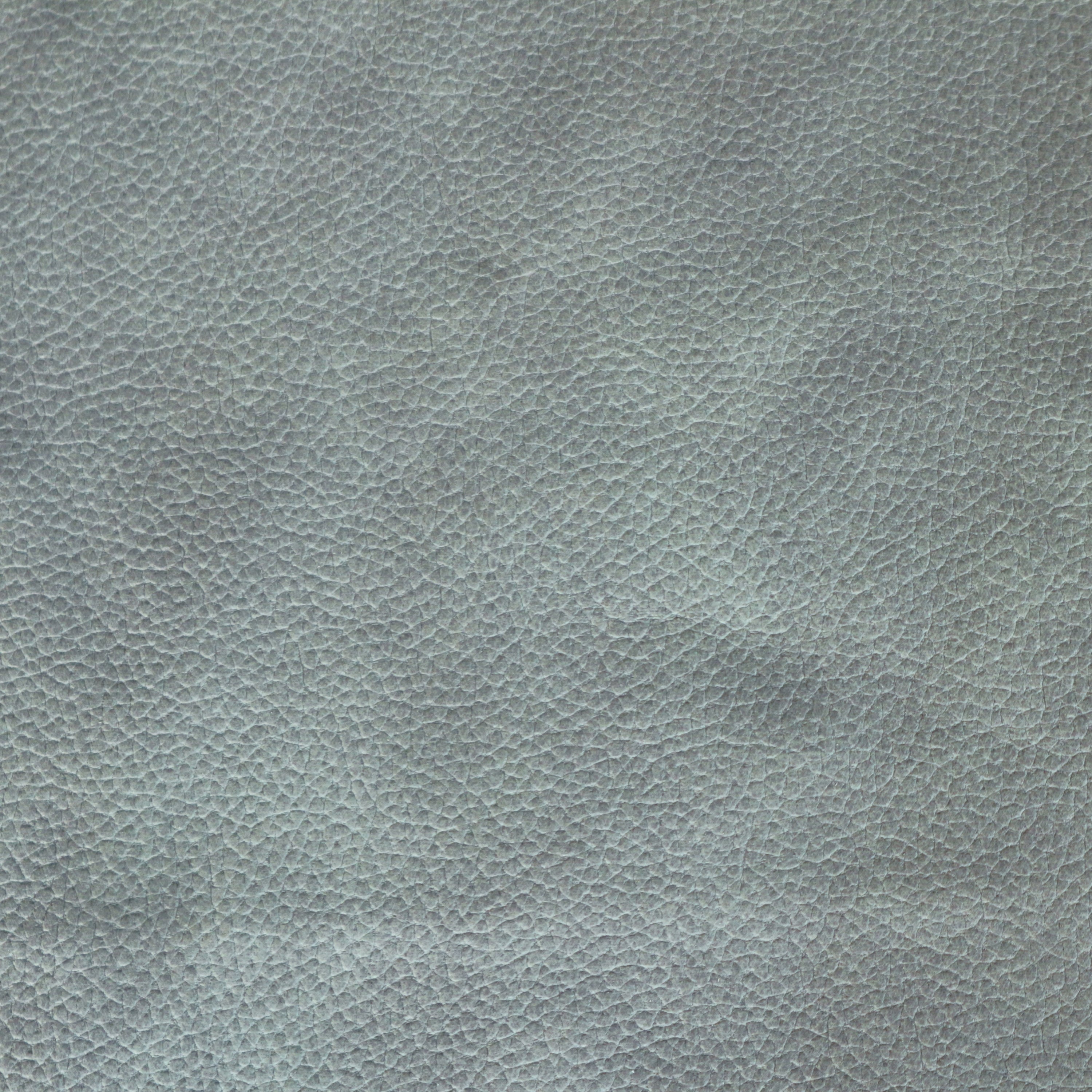 Close-up of blue faux leather upholstery showing a pebbled grain texture, suitable for a dining chair seat.