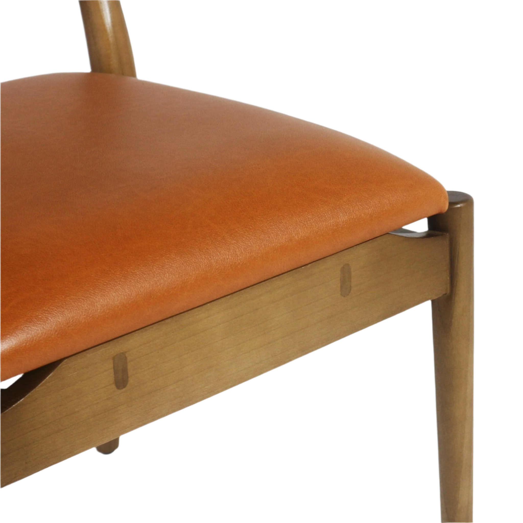 Close-up of a warm tan faux leather upholstered seat on a light natural wood side chair frame, showing the rounded leg and visible dowel joinery.