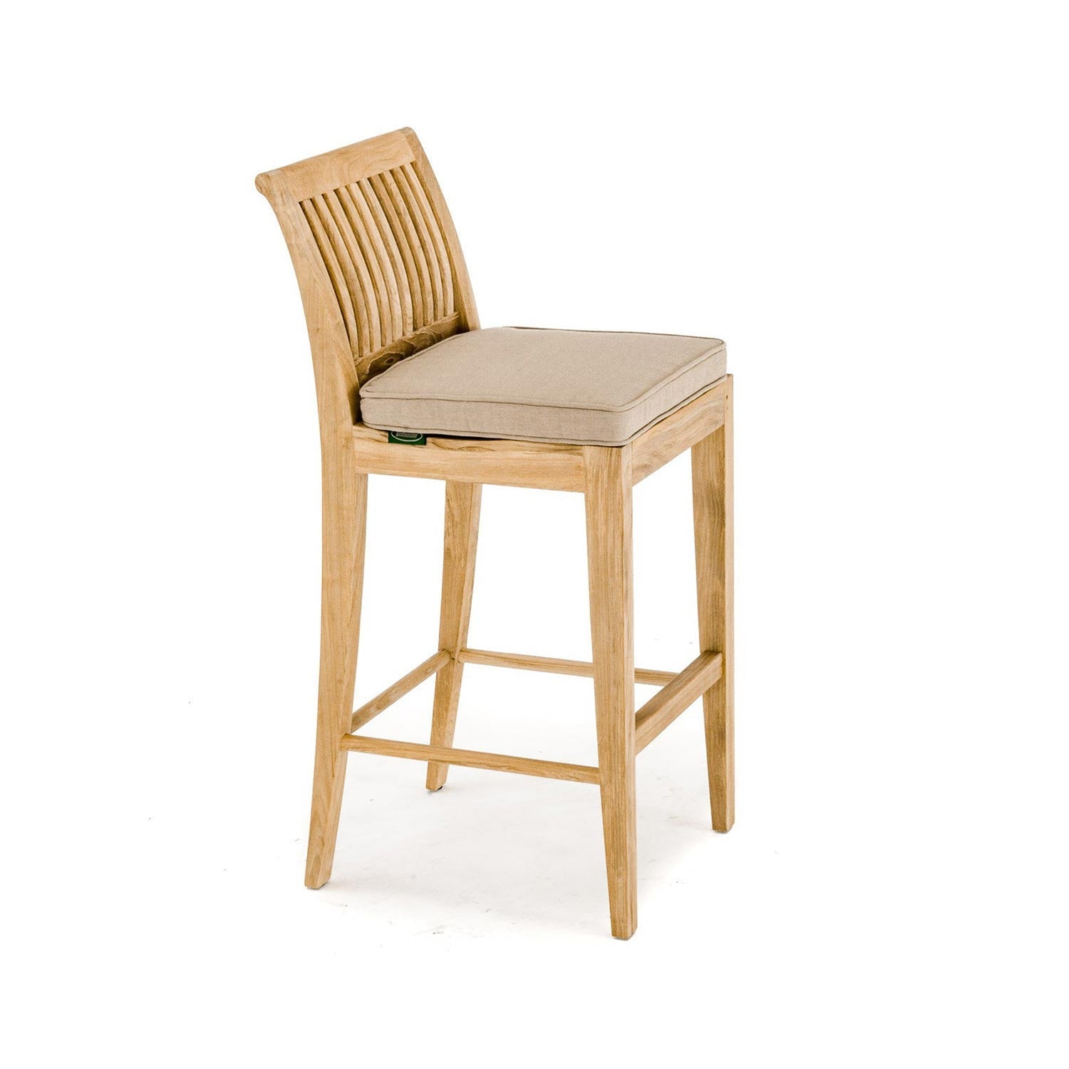 Natural teak armless outdoor bar stool with curved slatted back, beige upholstered seat cushion, tapered square legs and integrated footrest in a coastal style.