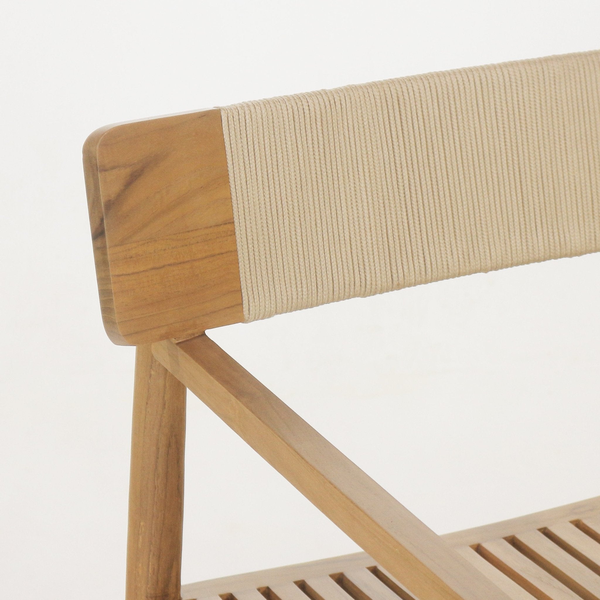 Close-up of a natural teak outdoor dining chair back with cream woven rope wrapped around the backrest and an angled teak support above a slatted seat.