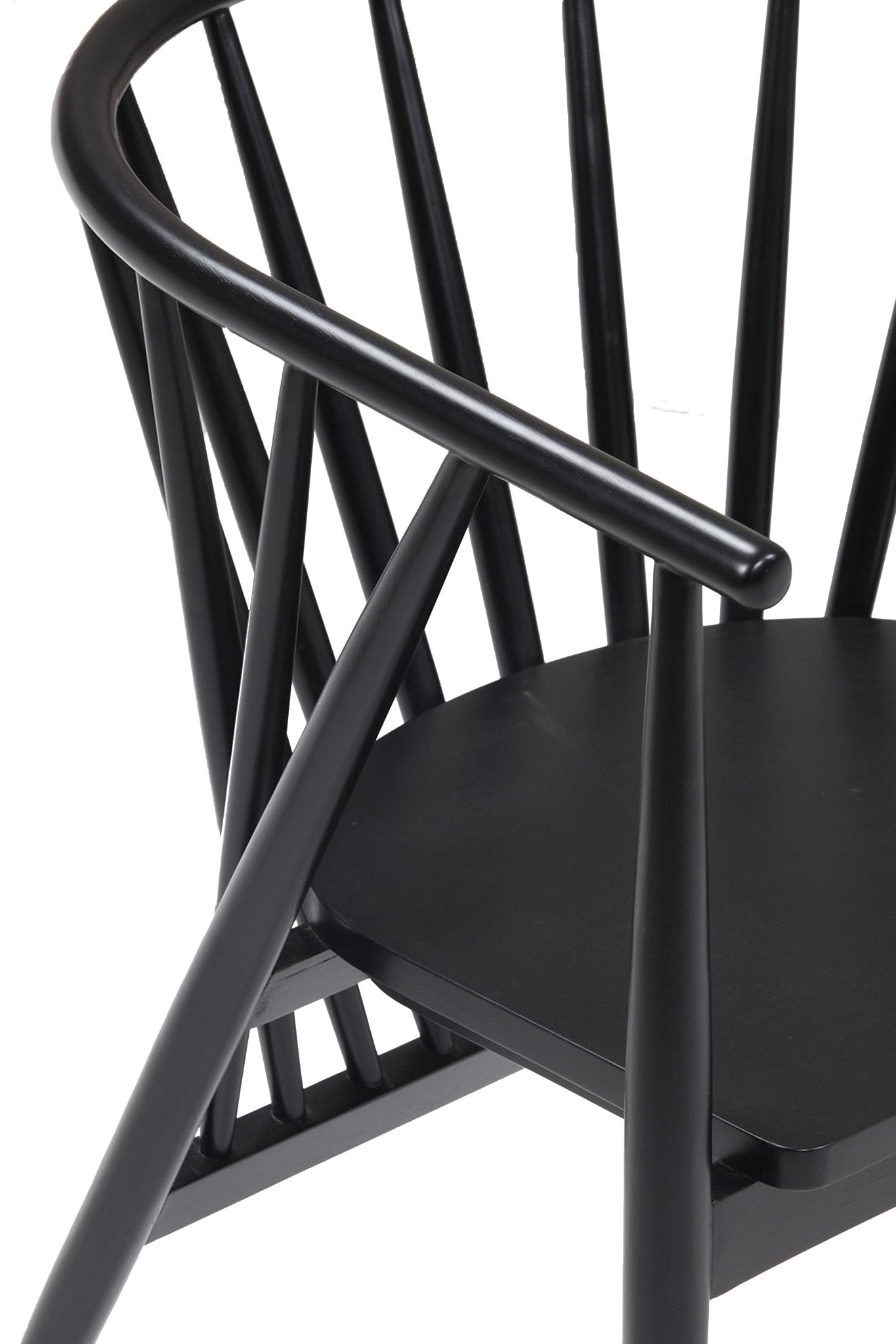 Close-up of a black-painted solid wood Shaker-style dining chair showing the curved armrest, vertical spindle back and contoured seat.