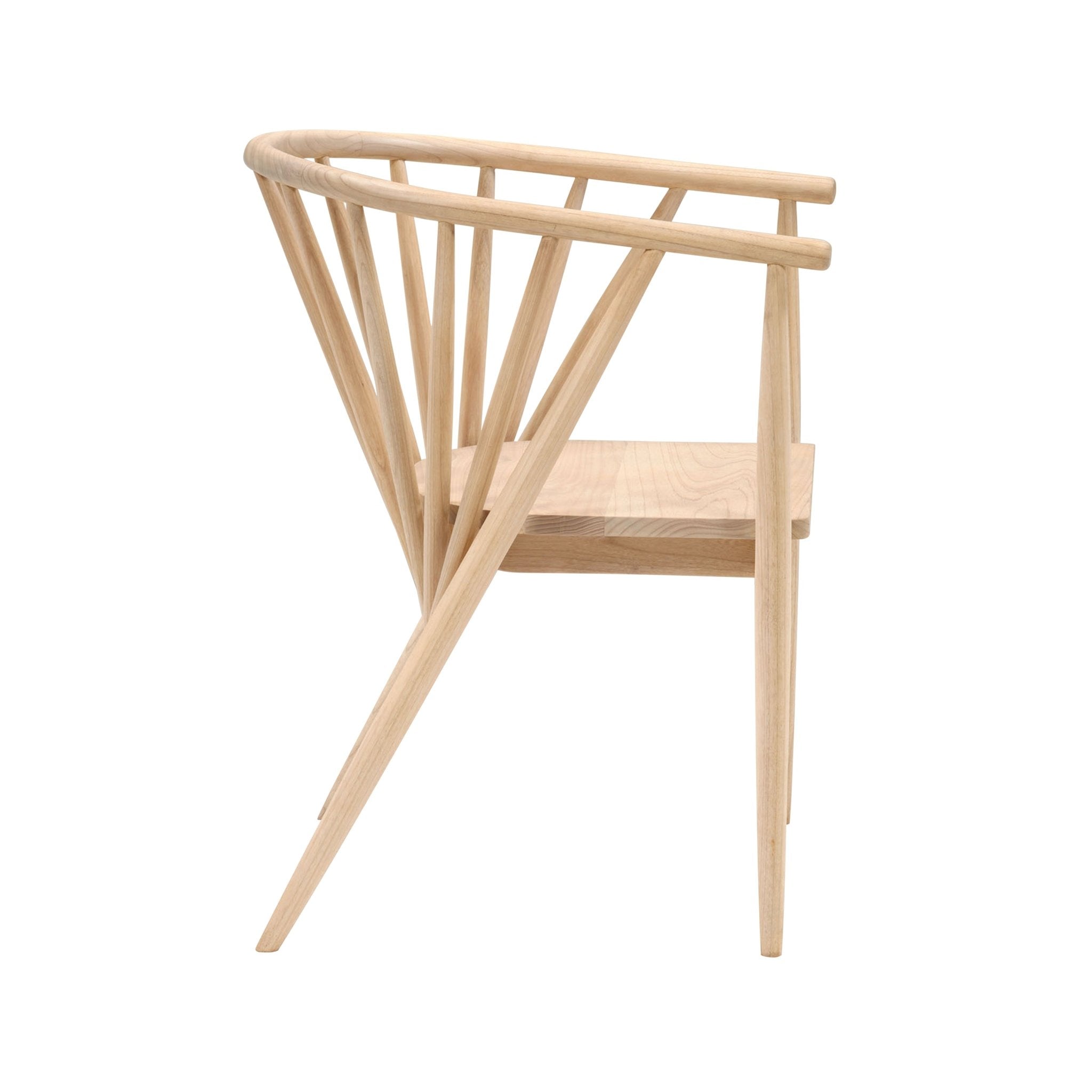 Side view of a natural teak dining armchair with a curved spindle back, angled tapered legs and light blonde finish in a Mid-Century Modern Shaker style.