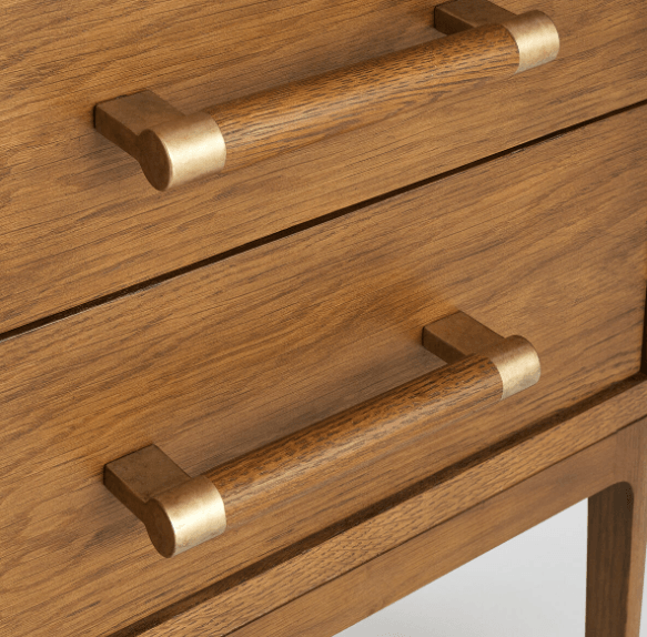 Close-up of two solid wood nightstand drawers with horizontal wooden pull handles capped in brass, showcasing warm brown wood grain and brushed brass hardware accents.