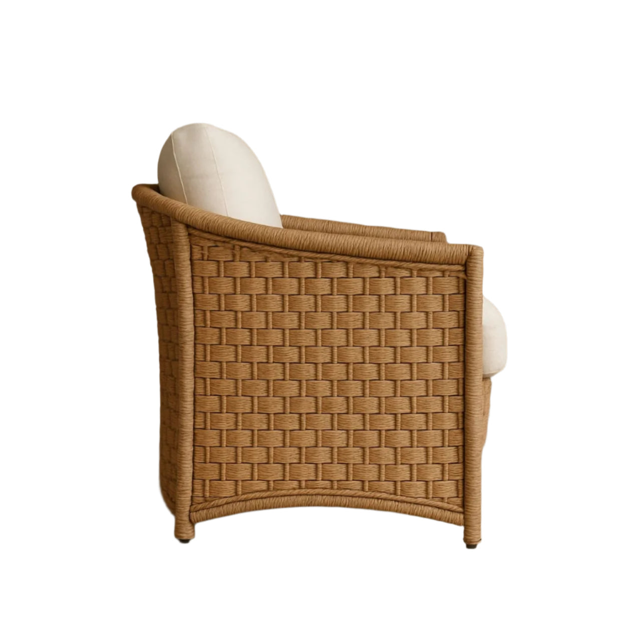 Side profile of a boho-style synthetic rattan accent chair with a woven tan frame and cream cushioned seat and back, showing the curved arm and back detail designed for outdoor all-weather use.