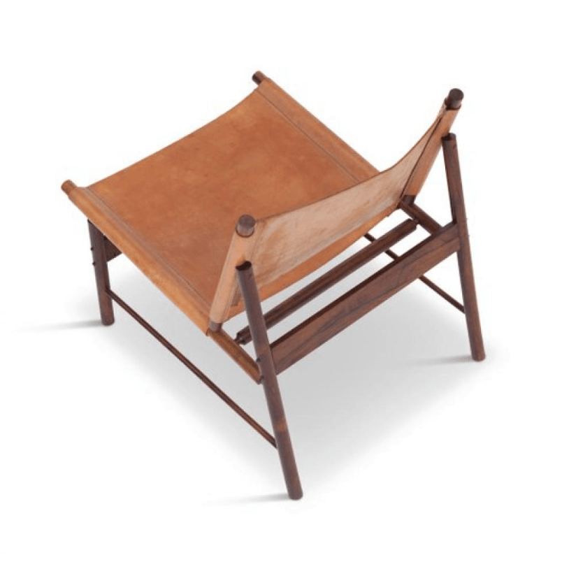 Mid century modern armless sling chair with tan leather seat stretched over a dark teak wood frame, photographed on a white background.