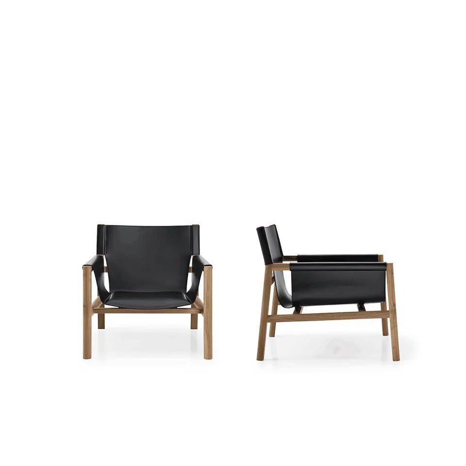 Front and side views of a mid-century modern accent chair with a black leather sling seat and natural teak wood frame on a white background.