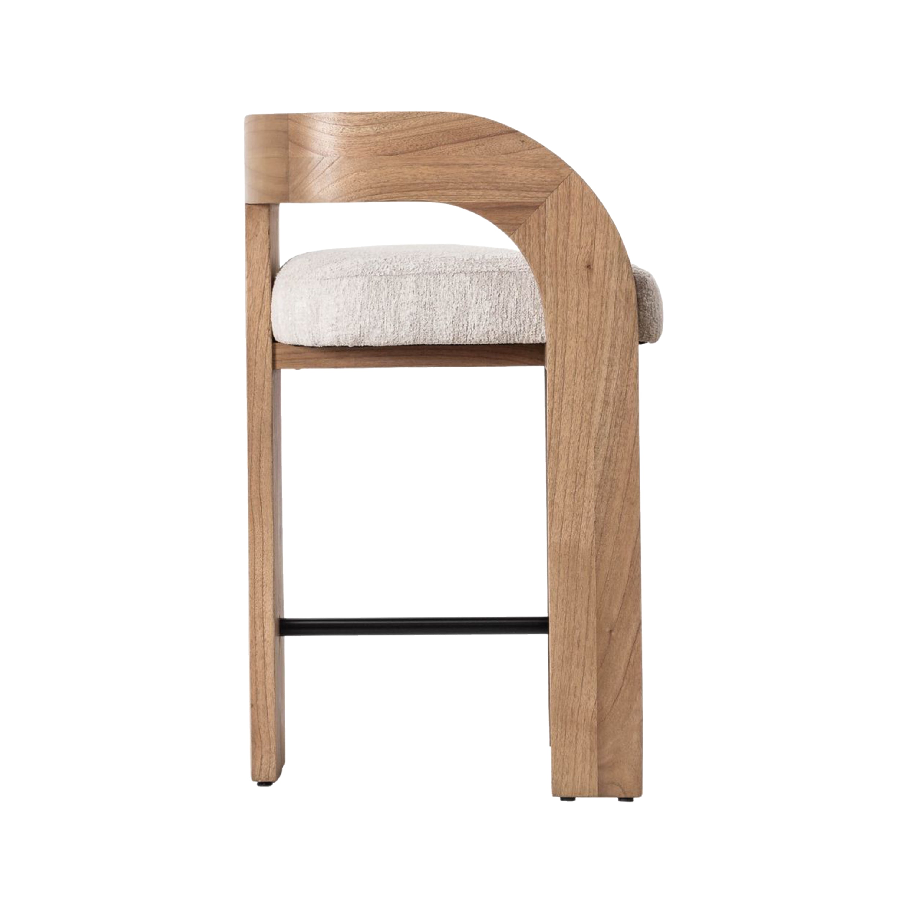 Side profile of a counter-height stool with a natural wood U-shaped back and integrated armrest, cream boucle upholstered seat cushion and a slim black metal footrest on a white background.