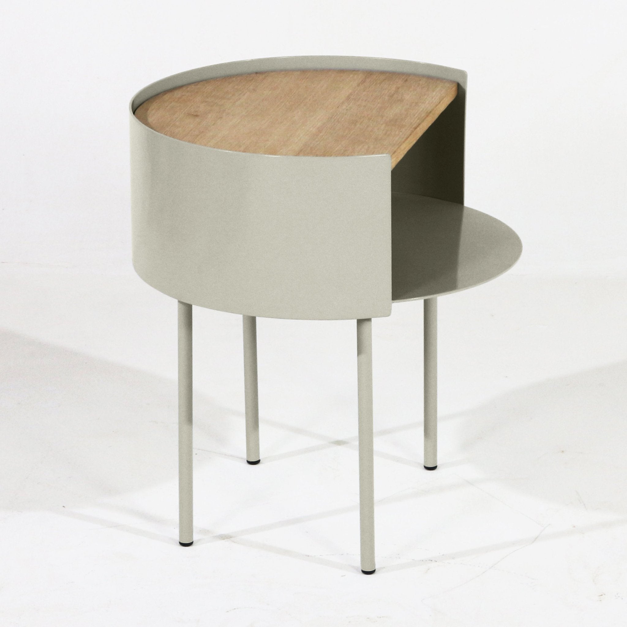 Modern nightstand with a white oak top set into a light gray steel curved shell, featuring an open circular lower shelf and four slender steel legs.