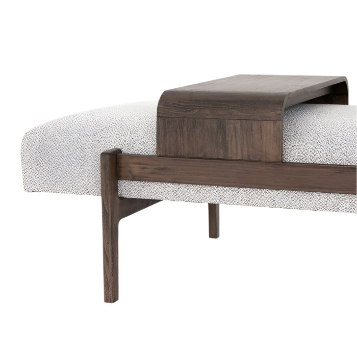 Close-up of a modern end-of-bed bench showing cream boucle fabric upholstery on the seat and a dark-stained solid wood frame with an integrated curved wood tray and tapered legs.