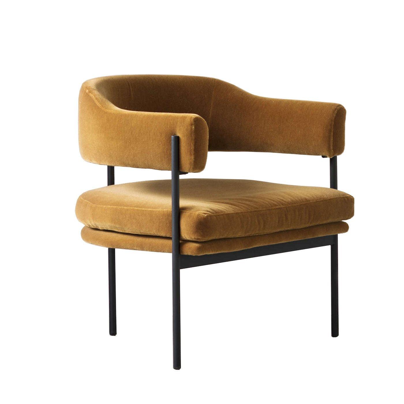 Mustard velvet lounge chair with a curved low back, open-sided armrests, plush double-layer seat cushion and slim black metal legs and supports, shown on a white background.
