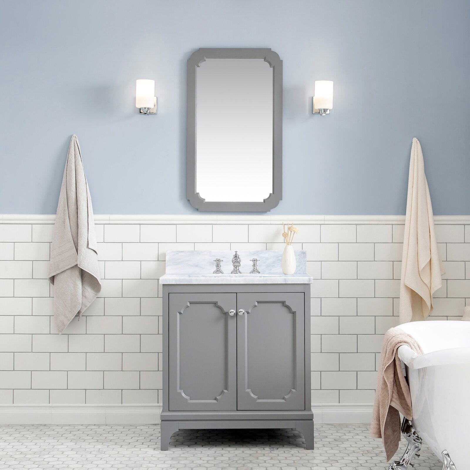 Single-sink solid wood vanity with Carrara white marble countertop and chrome waterfall faucet, shown in a gray painted finish against white subway tile, mirrored sconce lighting and a clawfoot tub in a contemporary glam bathroom.