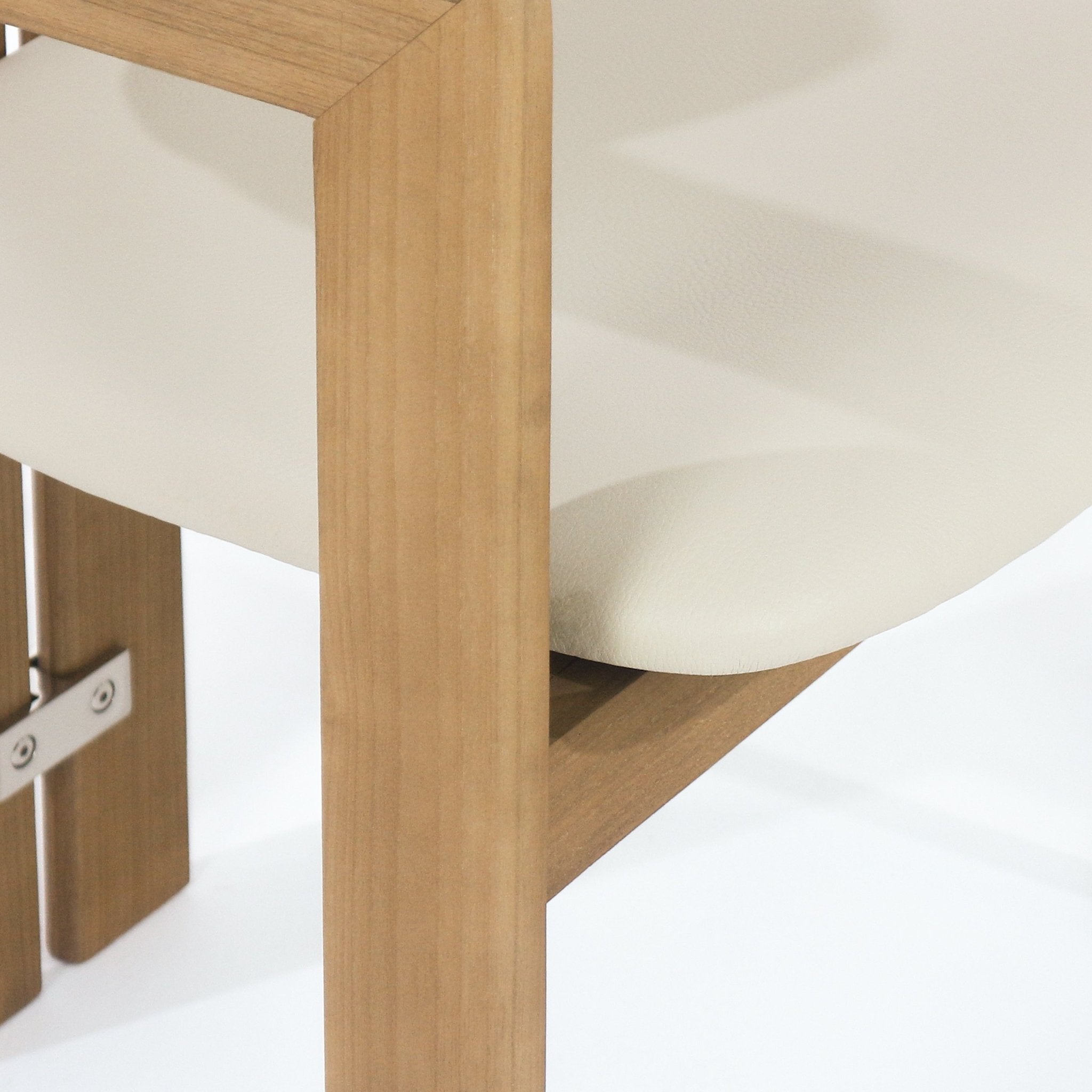 Close-up of a teak wood chair frame showing an angled support and the beige leather upholstered seat edge with a visible stainless-steel bracket and screws.