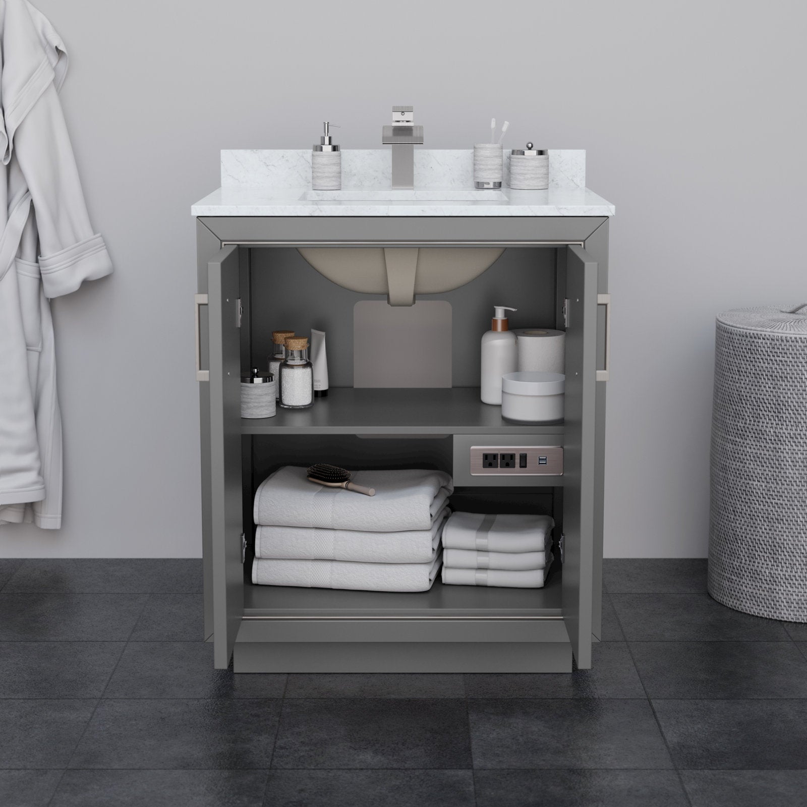 30-inch modern solid wood bathroom vanity in stone finish with a white stone countertop and integrated sink; open doors reveal two shelves with folded white towels, toiletries, a built-in outlet and square chrome faucet.