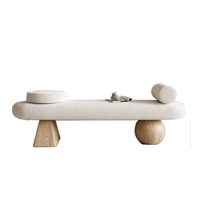 Cream boucle upholstered 59-inch end-of-bed bench with a round bolster and round seat cushion, supported by mixed solid wood legs — a tapered block on one end and a spherical wood leg on the other.
