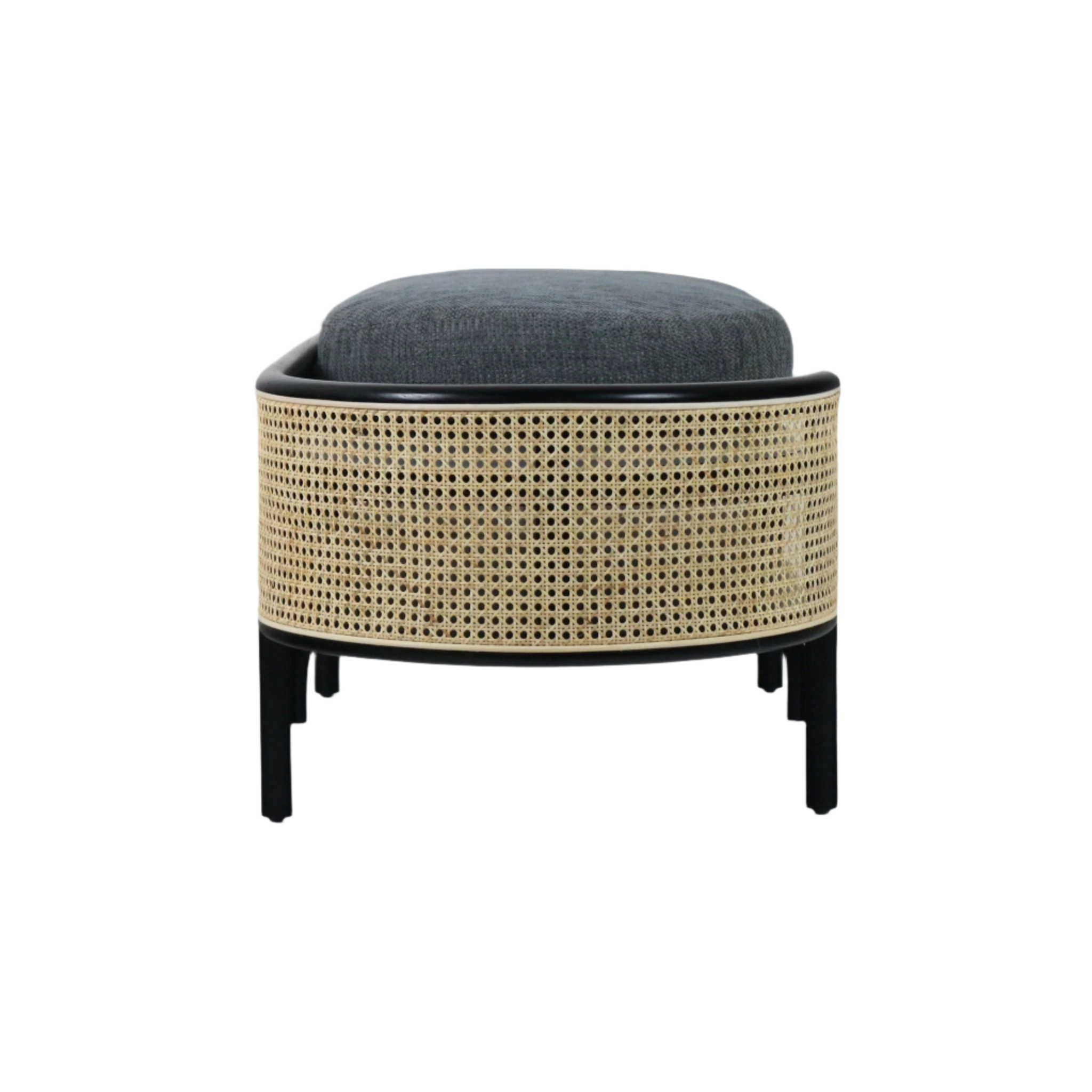 Front view of a low, backless bench with natural rattan cane wrap, black solid wood legs and a thick dark gray upholstered cushion in a boho-contemporary style.