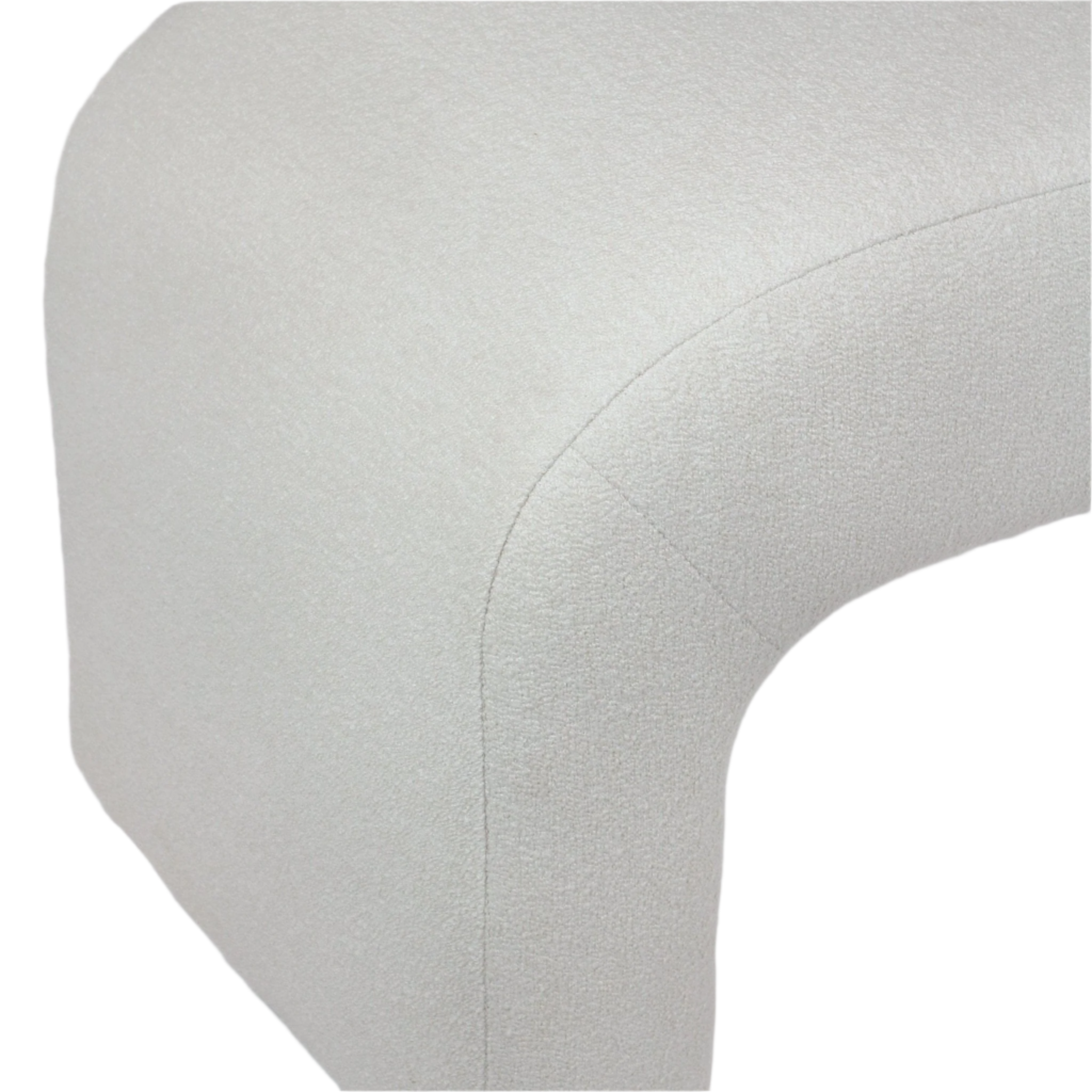 Close-up of a cream boucle upholstered end-of-bed bench corner showing the rounded edge, textured fabric and visible stitched seam.
