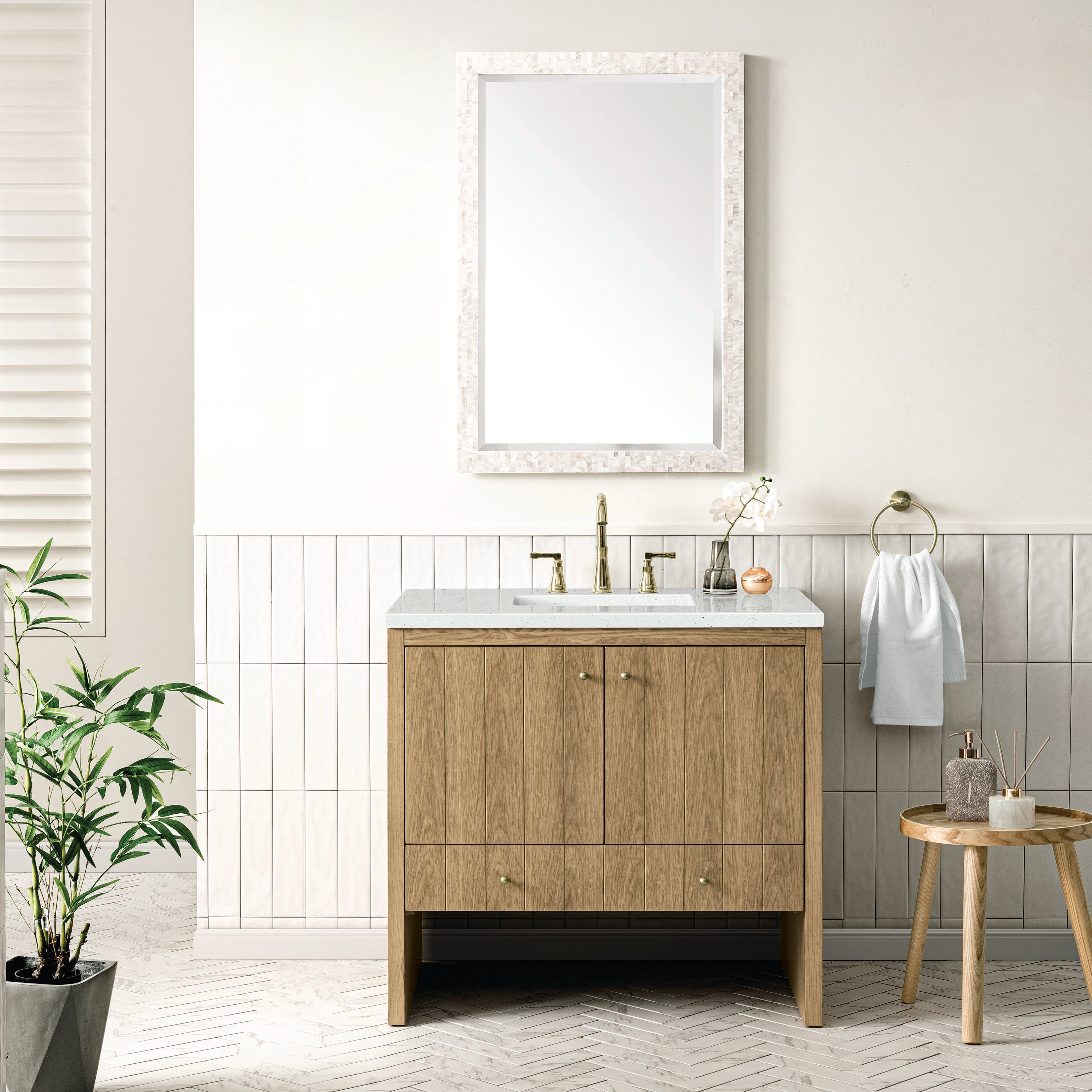 36-inch natural oak single-sink bathroom vanity with light stone quartz top, rectangular undermount ceramic sink, brass widespread faucet, two-door storage and framed mirror, styled with a towel ring and wooden stool in a modern bath.