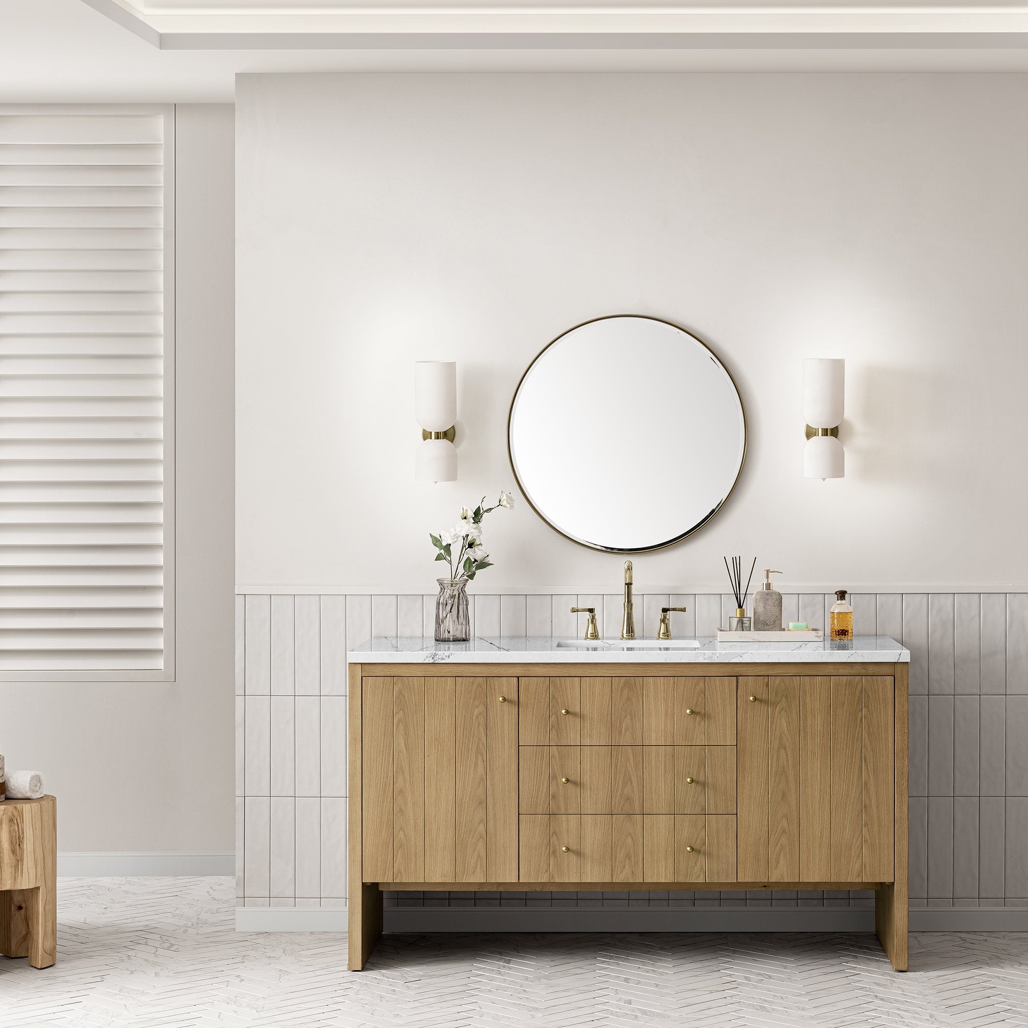 60-inch natural oak single-sink bathroom vanity with a stone quartz top, rectangular undermount ceramic sink and brass widespread faucet, styled with a round brass-framed mirror and two wall sconces in a modern bath.