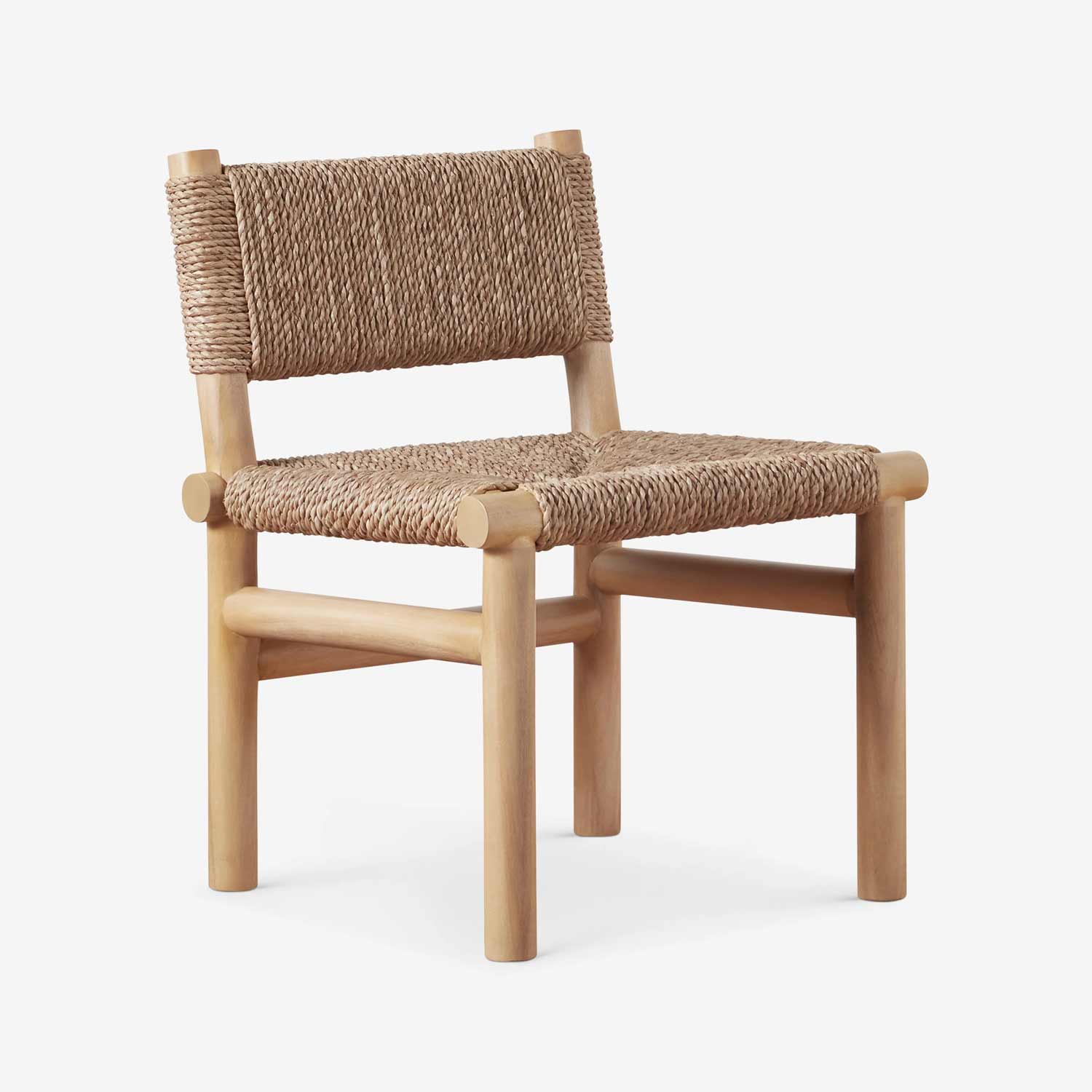 Armless outdoor dining chair with a natural teak solid wood frame and hand-woven natural rope seat and low back in a coastal-rustic style, shown in three-quarter view on a white background.