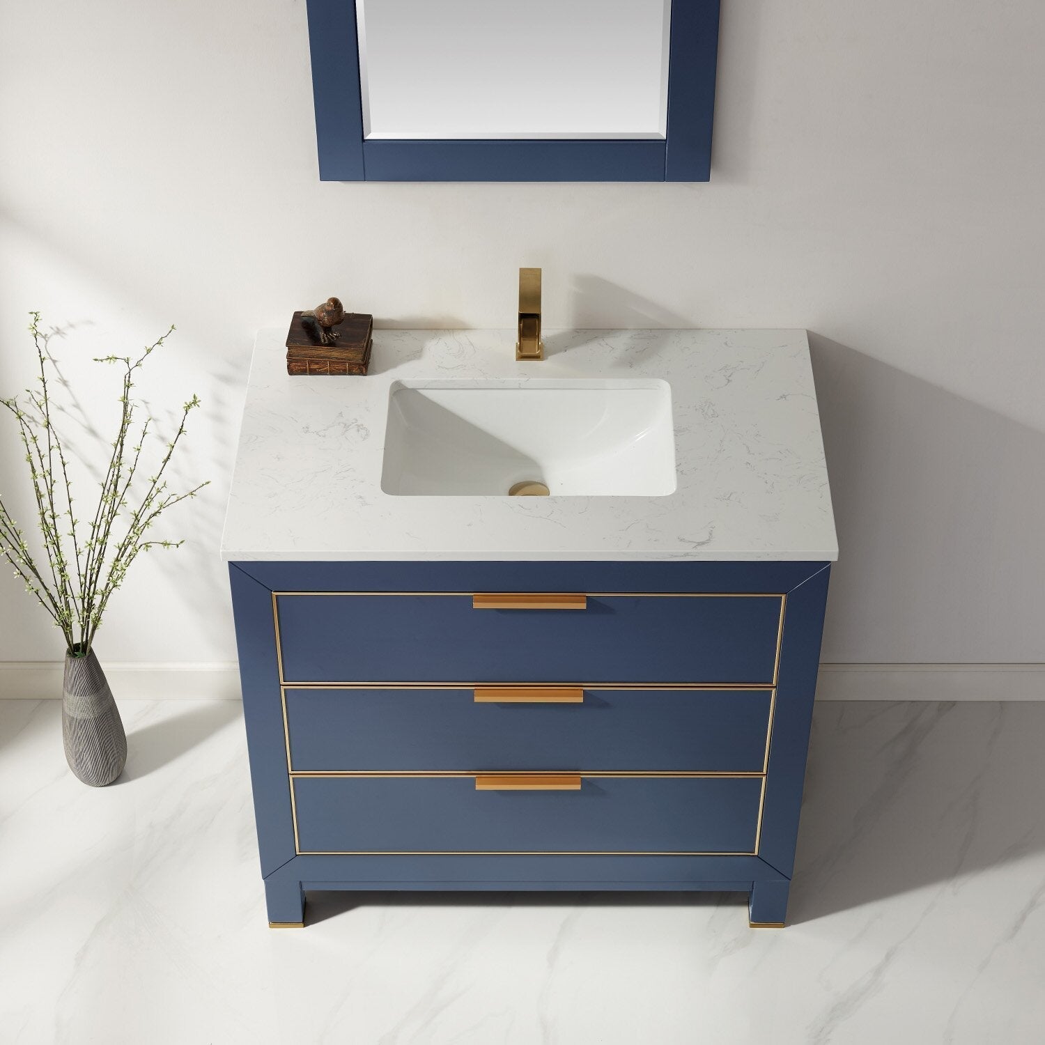 Modern solid wood 36-inch bathroom vanity in navy blue with a white stone countertop, integrated ceramic sink, and brass/gold faucet and drawer hardware with three drawers.