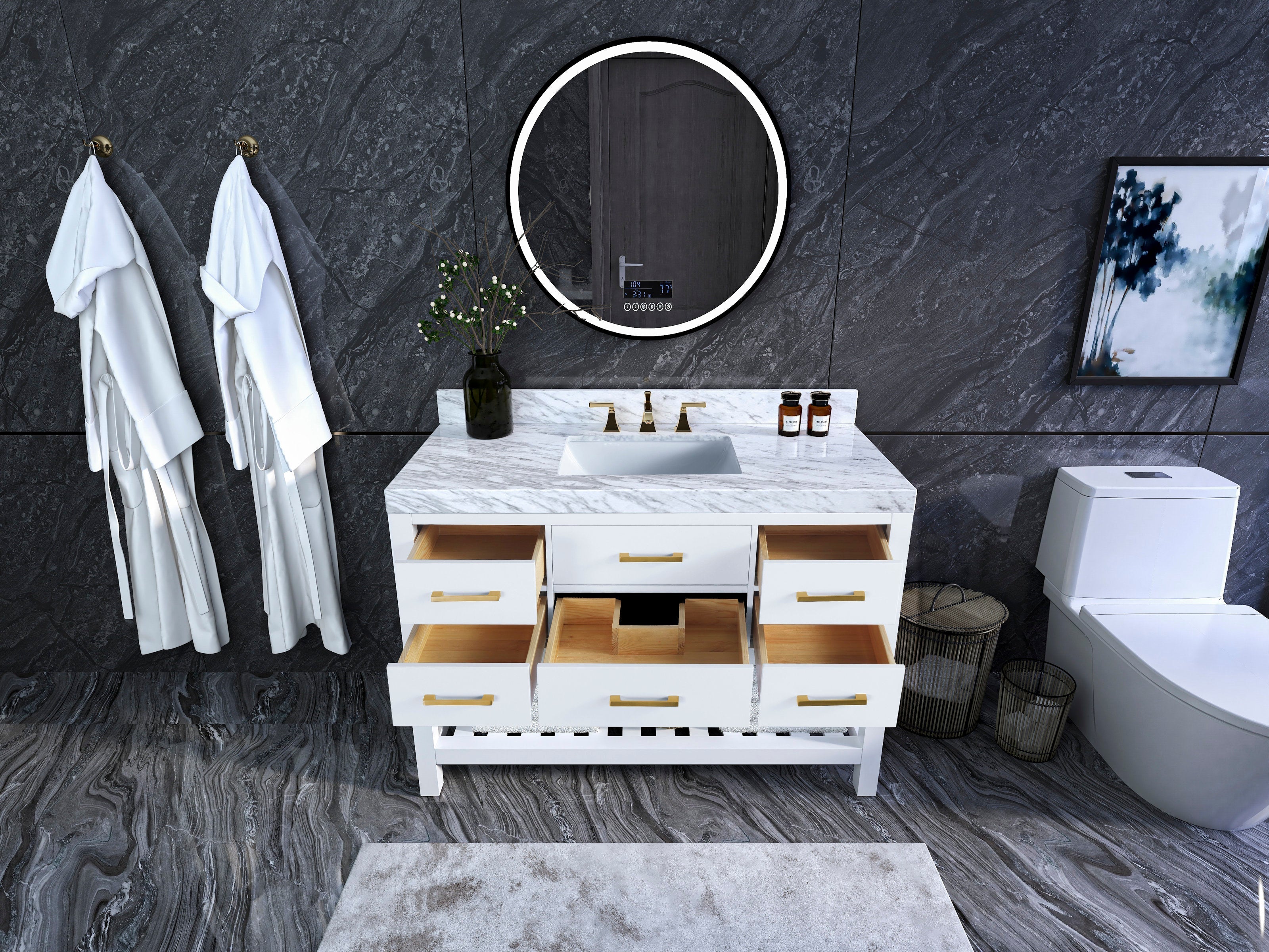 White solid-wood single-sink bathroom vanity with a white marble top, gold hardware and open drawers revealing wood interiors, shown with a round LED mirror, dark stone wall, hanging robes and a toilet to the right.