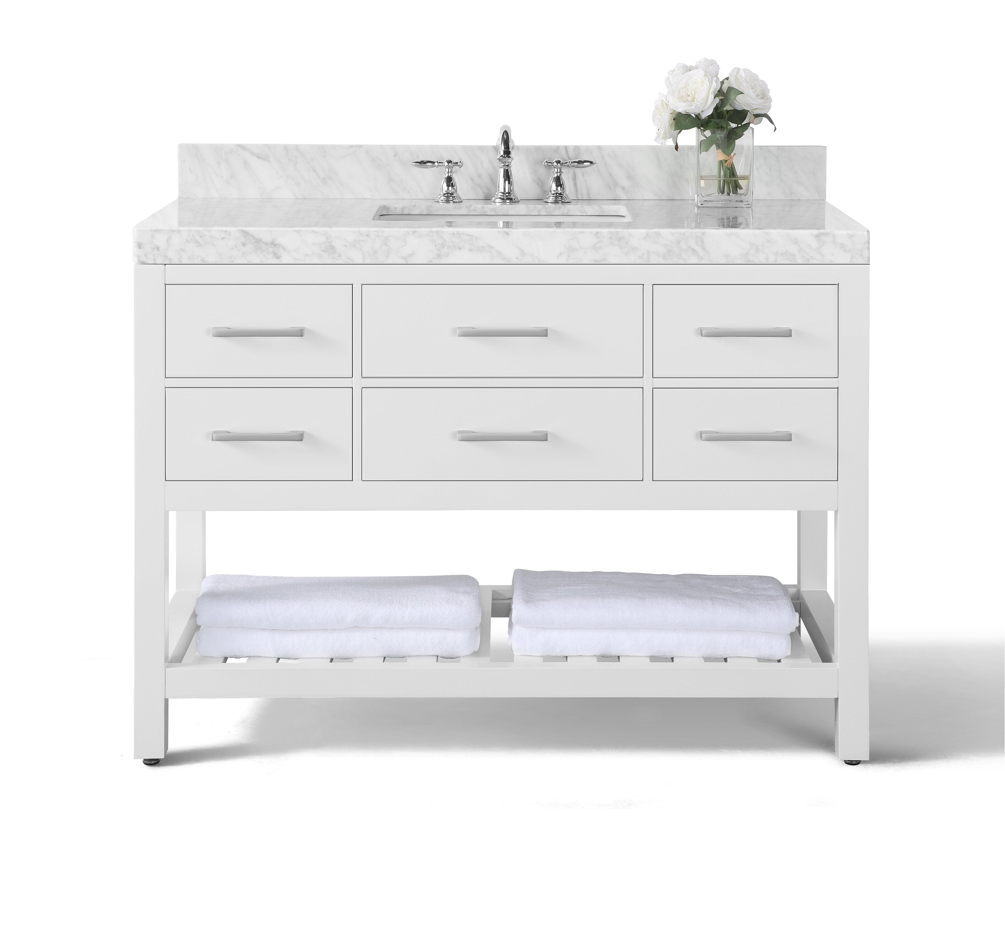 Modern 48-inch single-sink bathroom vanity with marble stone top and chrome faucet, integrated ceramic basin, white solid-wood frame with six drawers and an open slatted shelf holding folded white towels and a glass vase of white flowers.