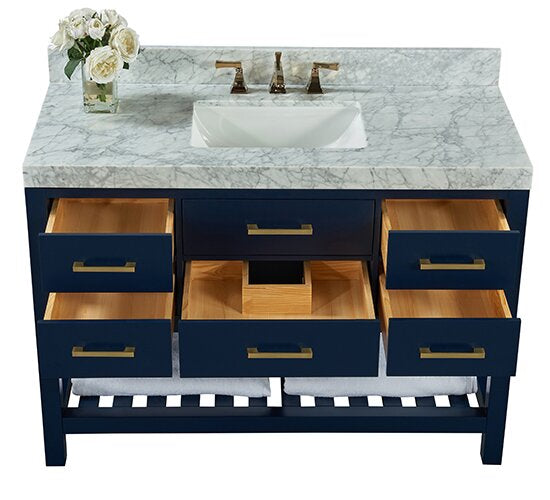 48-inch modern solid wood vanity with stone marble top and white undermount ceramic sink, navy-painted base with six open drawers showing natural wood interiors, brushed gold hardware and lower slatted towel shelf.