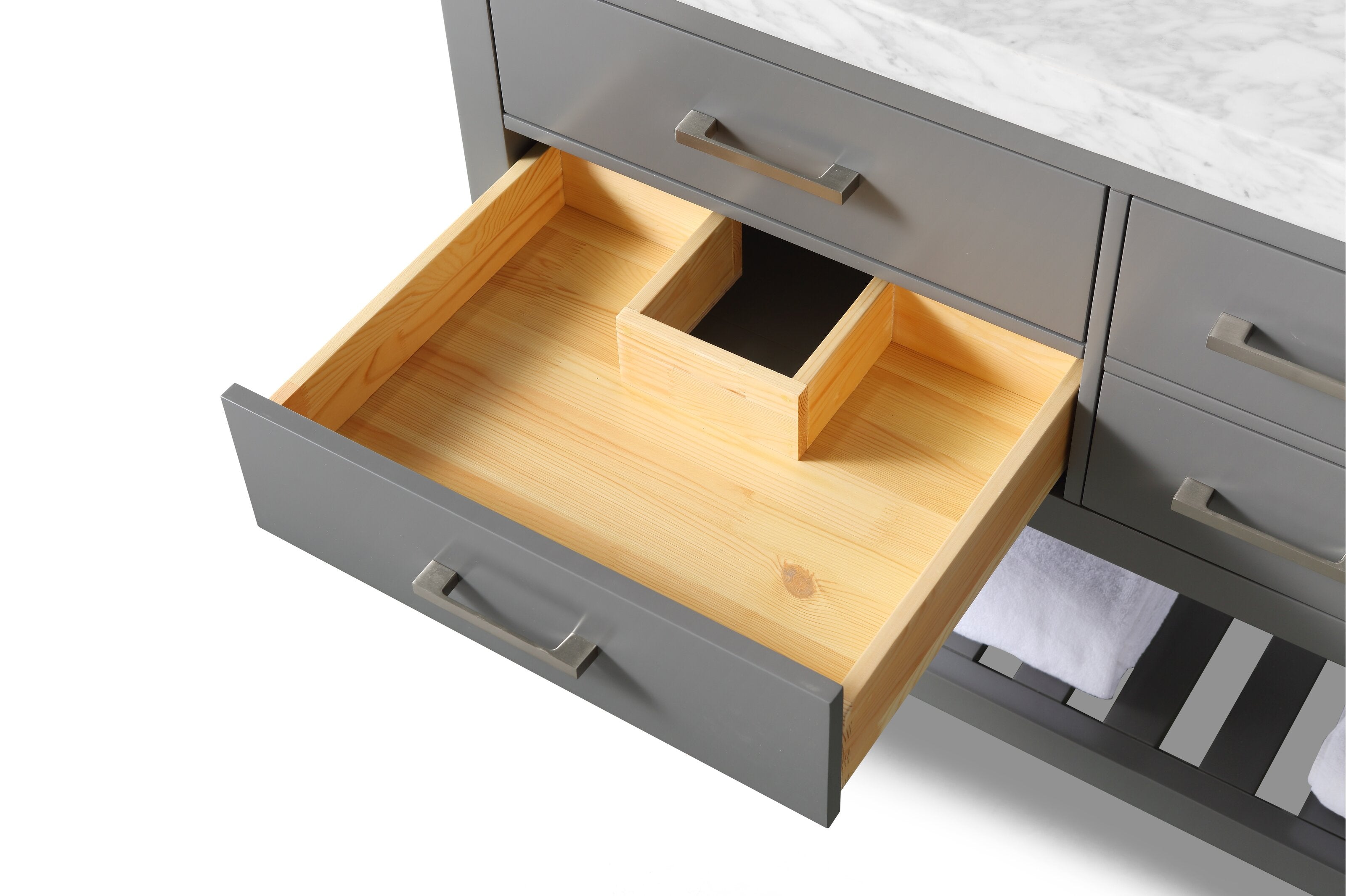 Close-up of a modern gray bathroom vanity with an open drawer revealing a light solid wood interior and U-shaped plumbing cutout, white stone countertop with marble veining, and brushed metal handles.