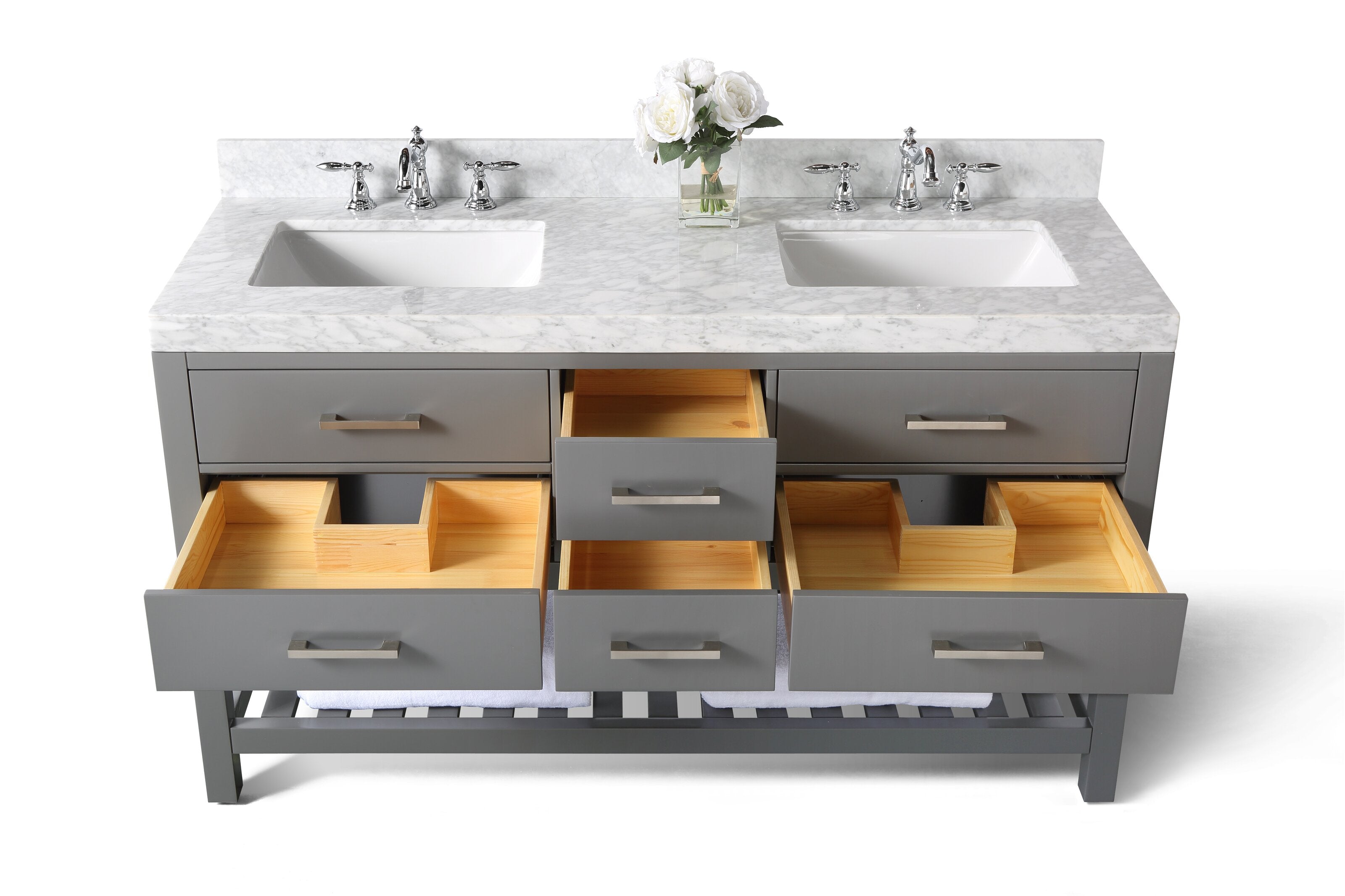 Stone-top gray solid wood 60-inch double-sink vanity with a marble countertop, two rectangular undermount sinks and chrome faucets, open drawers showing natural wood interiors and a slatted lower shelf with a folded towel and vase of white flowers.