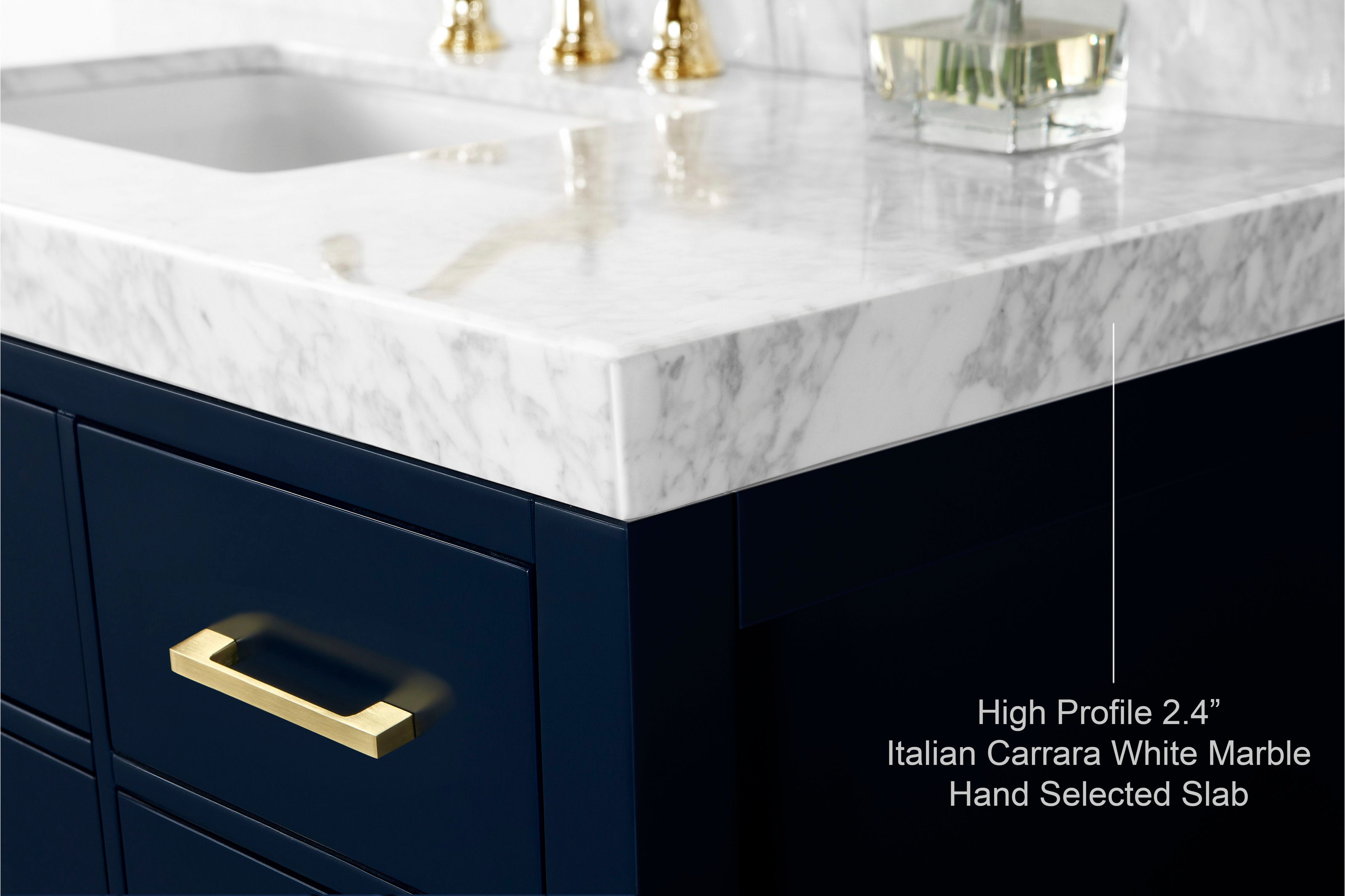 Close-up of a high-profile 2.4" Italian Carrara white marble countertop with an undermount sink on a modern navy solid-wood vanity, shown with a gold-brass drawer pull and veined stone edge.