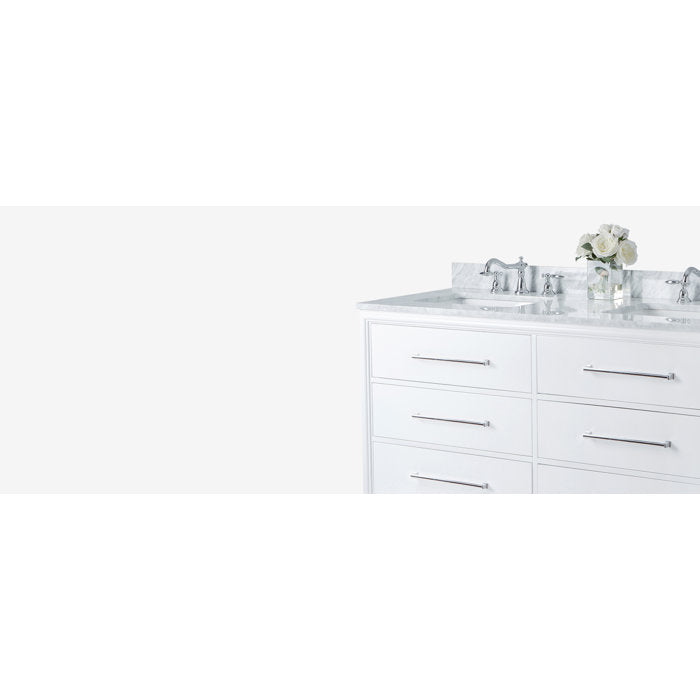 Right-side view of a modern white solid wood bathroom vanity with a stone countertop, two undermount sinks, chrome faucets and long horizontal chrome drawer pulls, styled with a small vase of white flowers.
