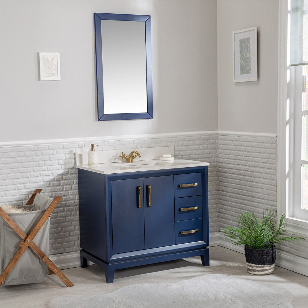 Freestanding navy solid-wood single-sink bathroom vanity with white stone top and integrated basin, brass faucet and handles, two-door cabinet and three drawers, shown with matching navy mirror in a modern bathroom.