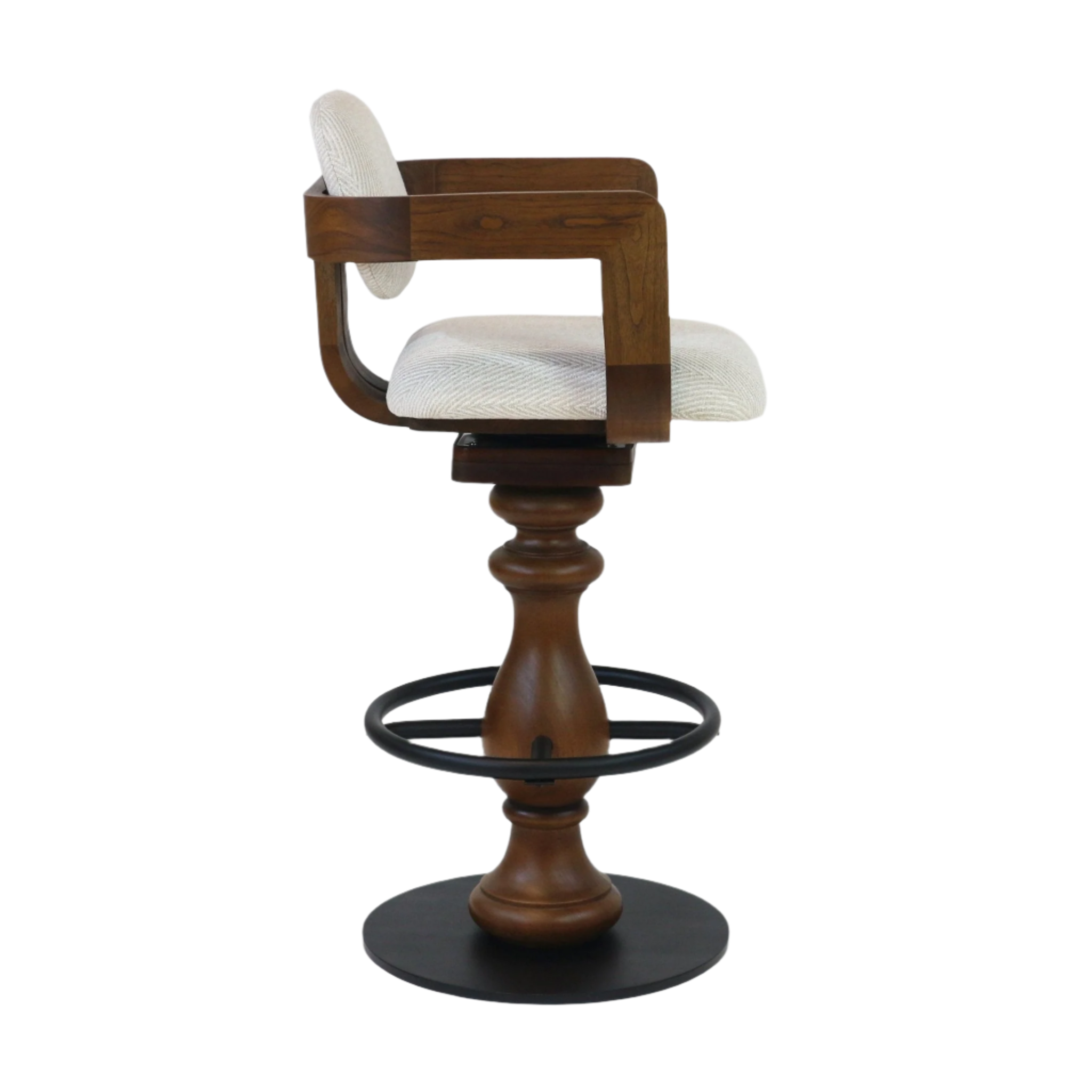 Side view of a beige fabric-upholstered bar stool with a curved wooden armback, turned natural wood pedestal, black metal circular footring and round base, and a swivel seat.