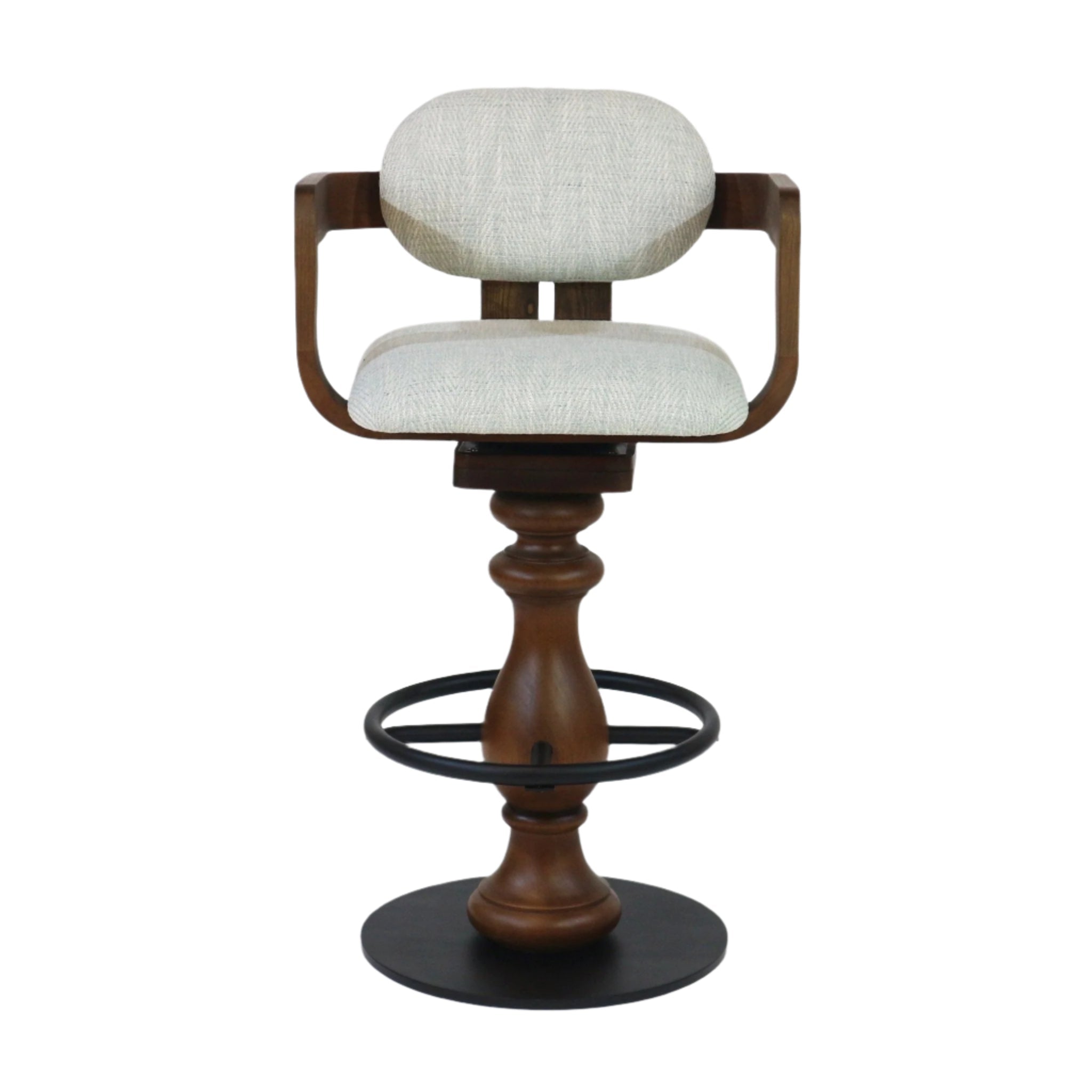 Front view of a light gray fabric-upholstered bar stool with curved wooden arms and oval cushioned back, turned natural wood pedestal, black metal circular footrest ring and round base in a counter-height swivel design.