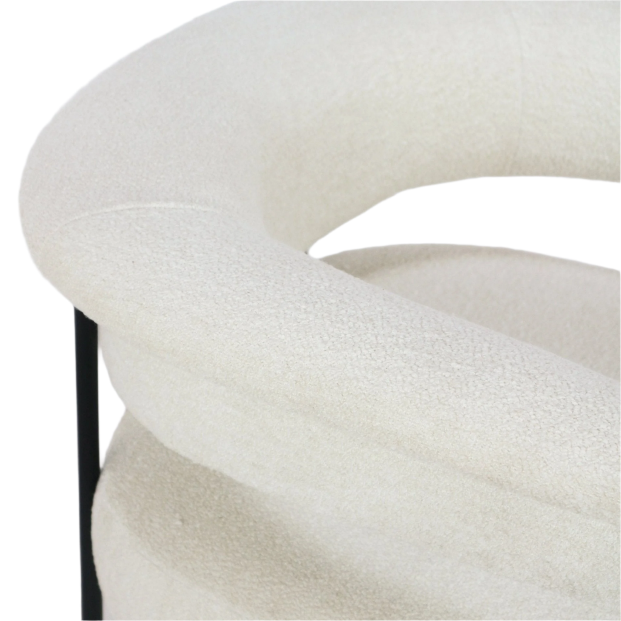 Close-up of a cream boucle upholstered dining chair showing the curved cushioned back and arm with textured boucle fabric and a slim black metal leg visible.