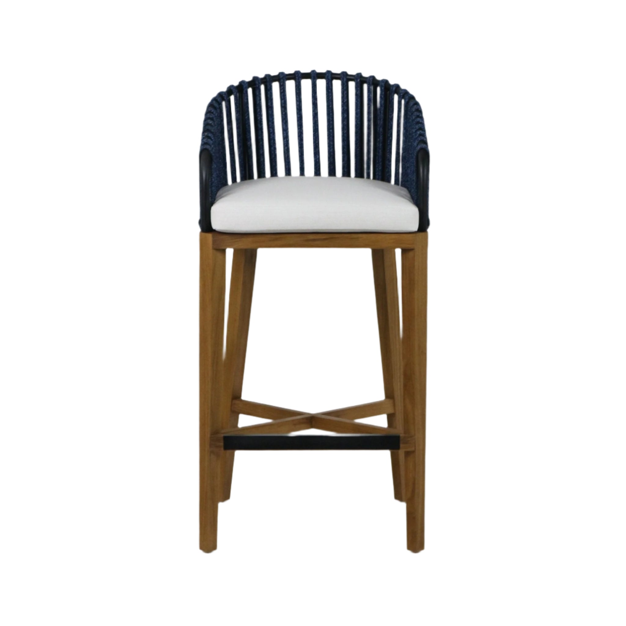 Front view of a teak outdoor bar stool with a navy woven rope curved back, white upholstered seat cushion, tapered teak legs with crossed stretcher and a black metal footrest.