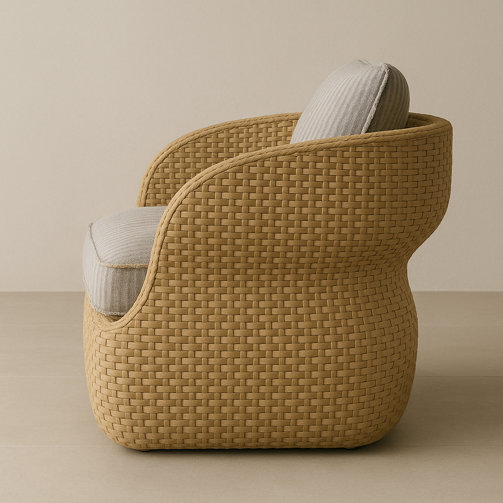 Side profile of a natural woven rattan outdoor accent chair with a rounded sculptural frame and light taupe-gray cushioned seat and matching back pillow.