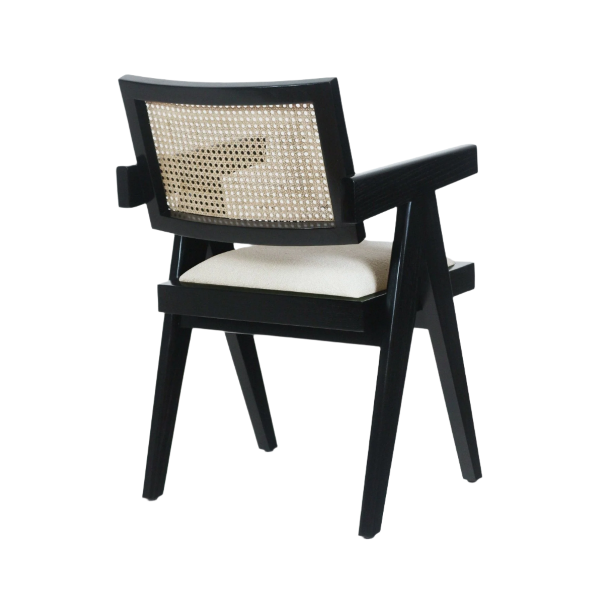 Three-quarter rear view of a mid-century modern dining chair with a black wood frame, natural cane woven back and a beige upholstered seat cushion, angled legs and solid wooden armrests.