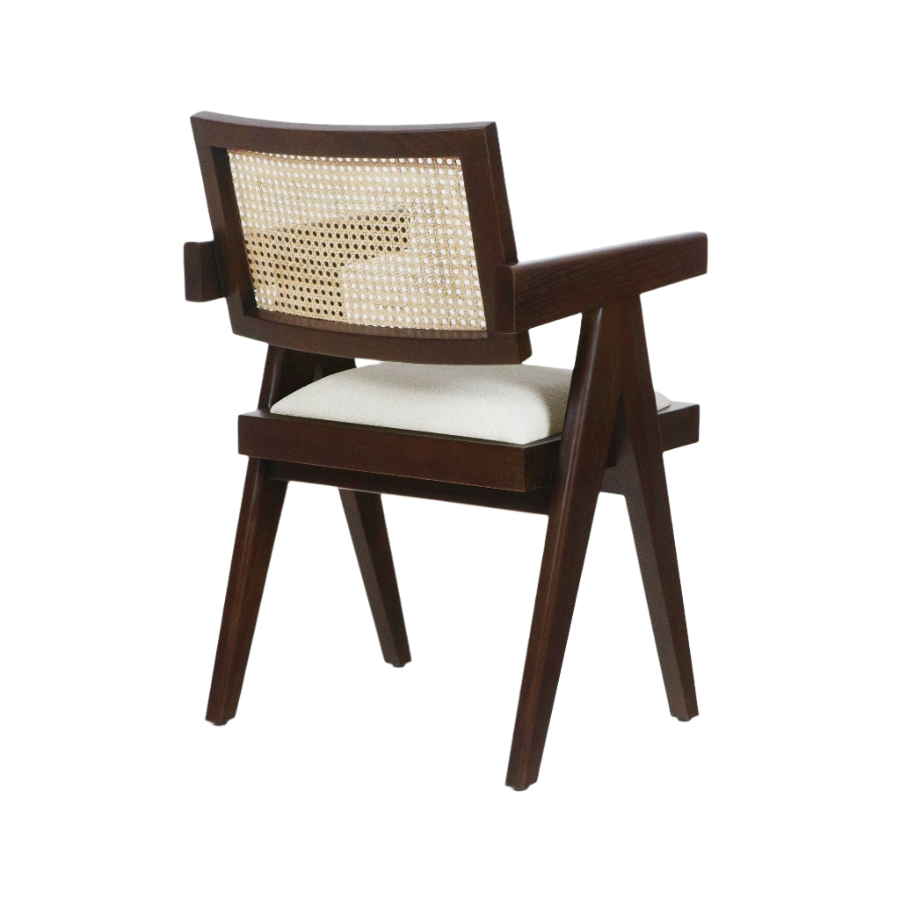Rear three-quarter view of a mid-century modern dining chair with walnut-toned solid wood frame, natural cane backrest and light beige upholstered seat cushion, angled legs and integrated wooden arms.
