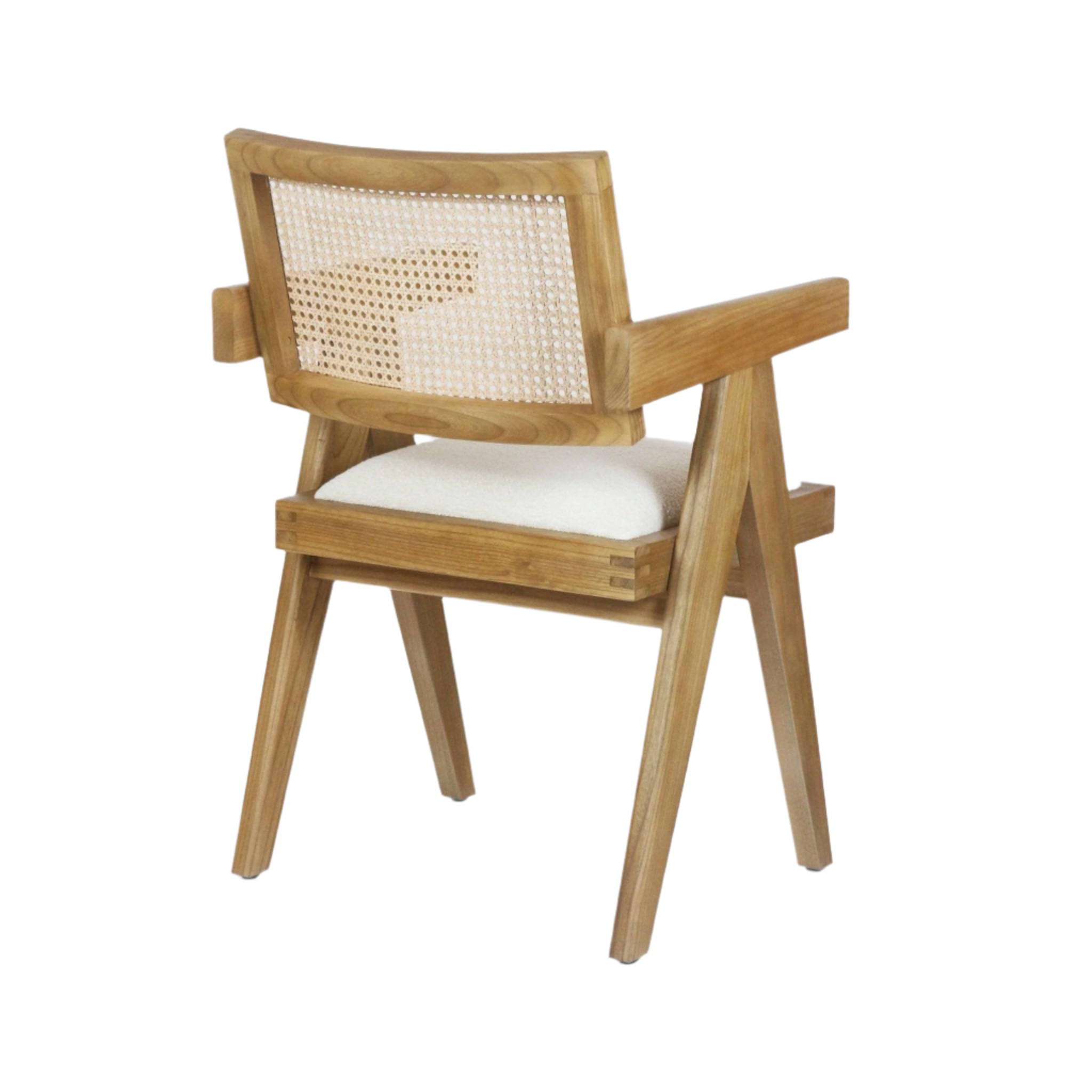 Three-quarter rear view of a natural blonde wood dining chair with woven cane back, off-white upholstered seat cushion, solid wood arms and angled mid-century legs.