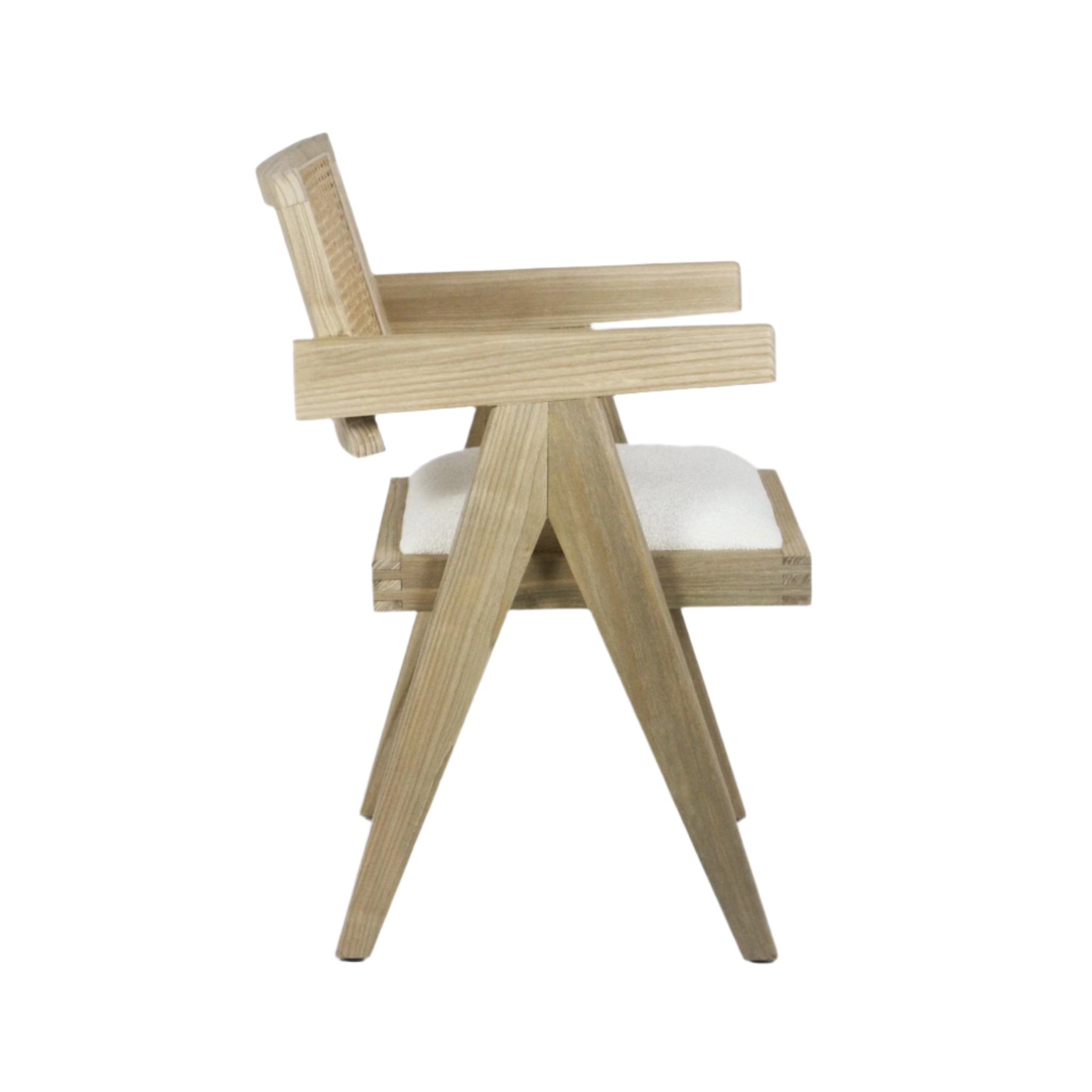 Side view of a natural wood dining chair with woven cane back, slanted mid-century modern legs, angular wooden arms, and a cream upholstered seat cushion.