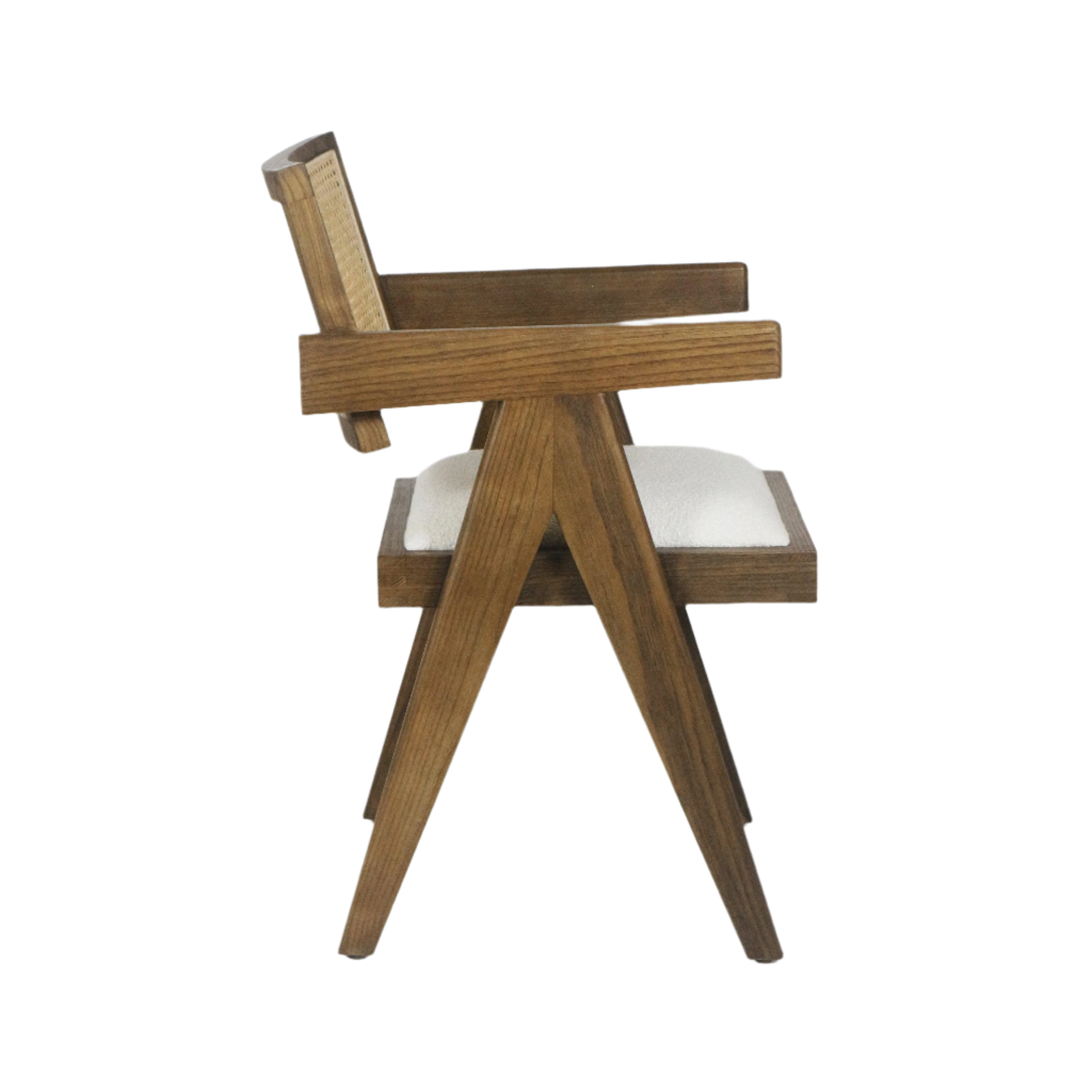 Side view of a mid-century modern natural wood dining chair with a caned back, angled A-frame legs, and a cream upholstered seat cushion against a white background.
