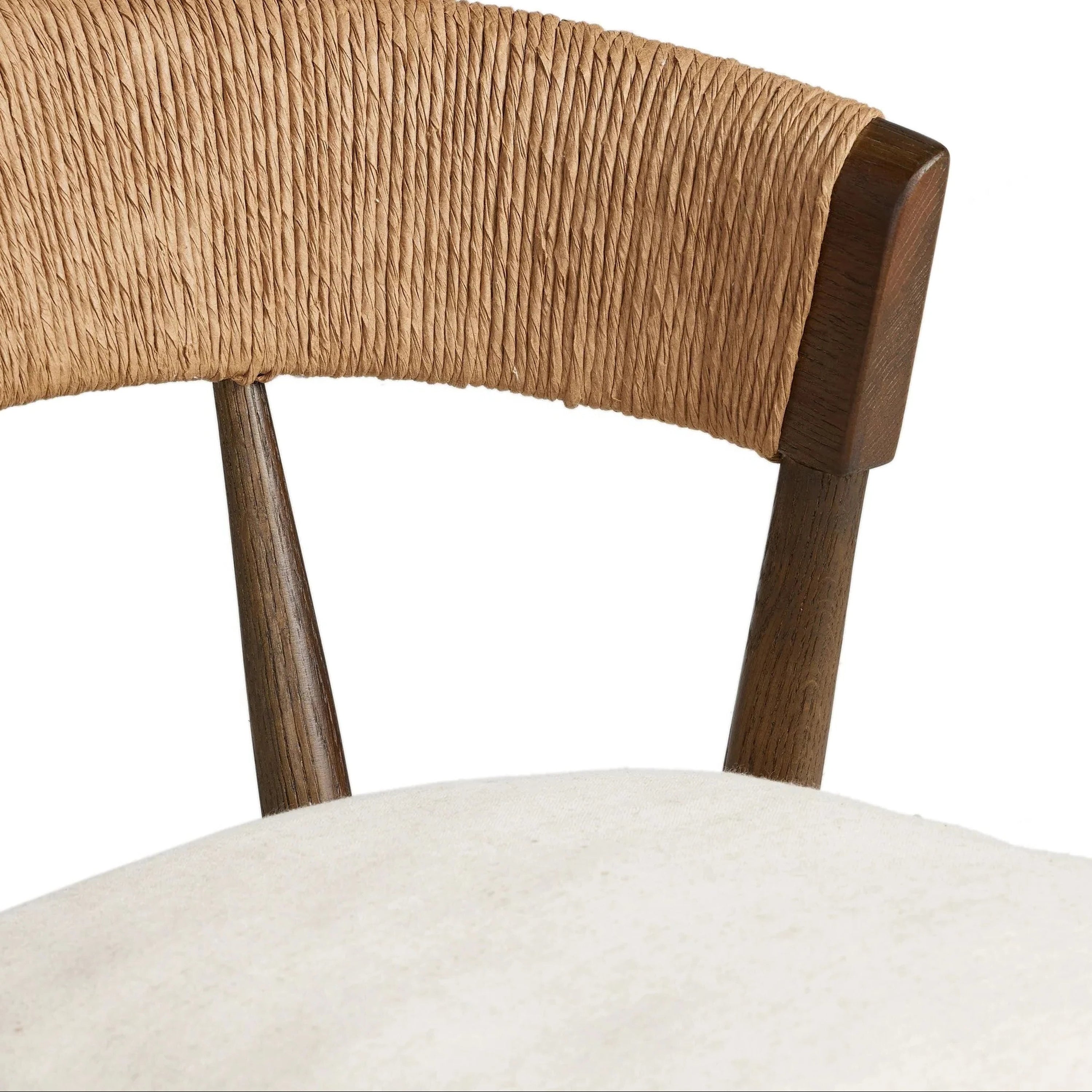 Close-up of a rustic farmhouse stool showing a natural rope-wrapped C-back attached to a dark wood frame above a cream fabric cushioned seat.
