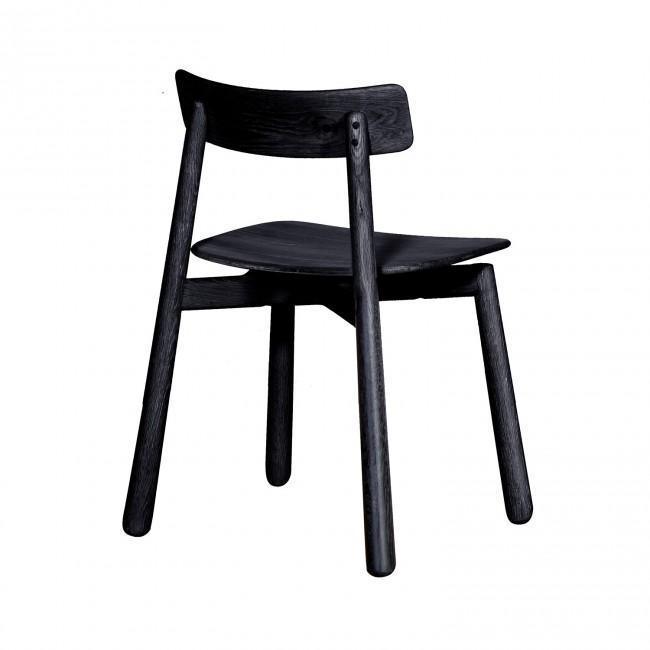 Armless mid-century Danish dining chair in black-stained mahogany with a curved backrest, gently scooped seat and round tapered legs against a white background.