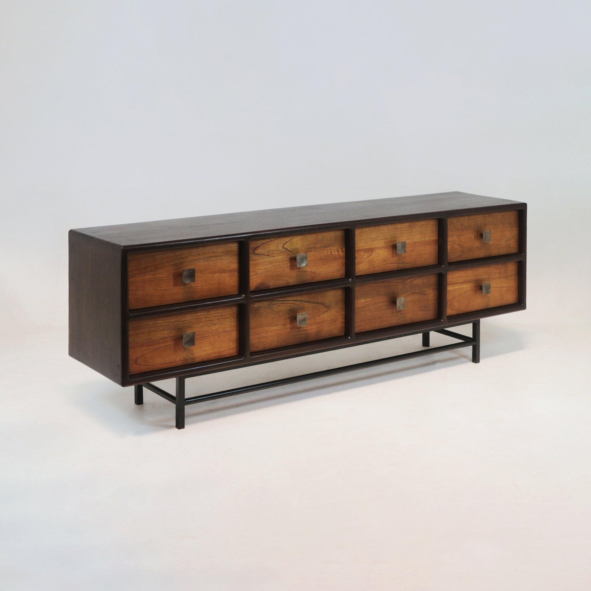 Long mid-century modern teak sideboard with eight recessed teak drawer fronts, square iron pulls and a slim black iron base, finished in warm brown teak tones for living room storage.