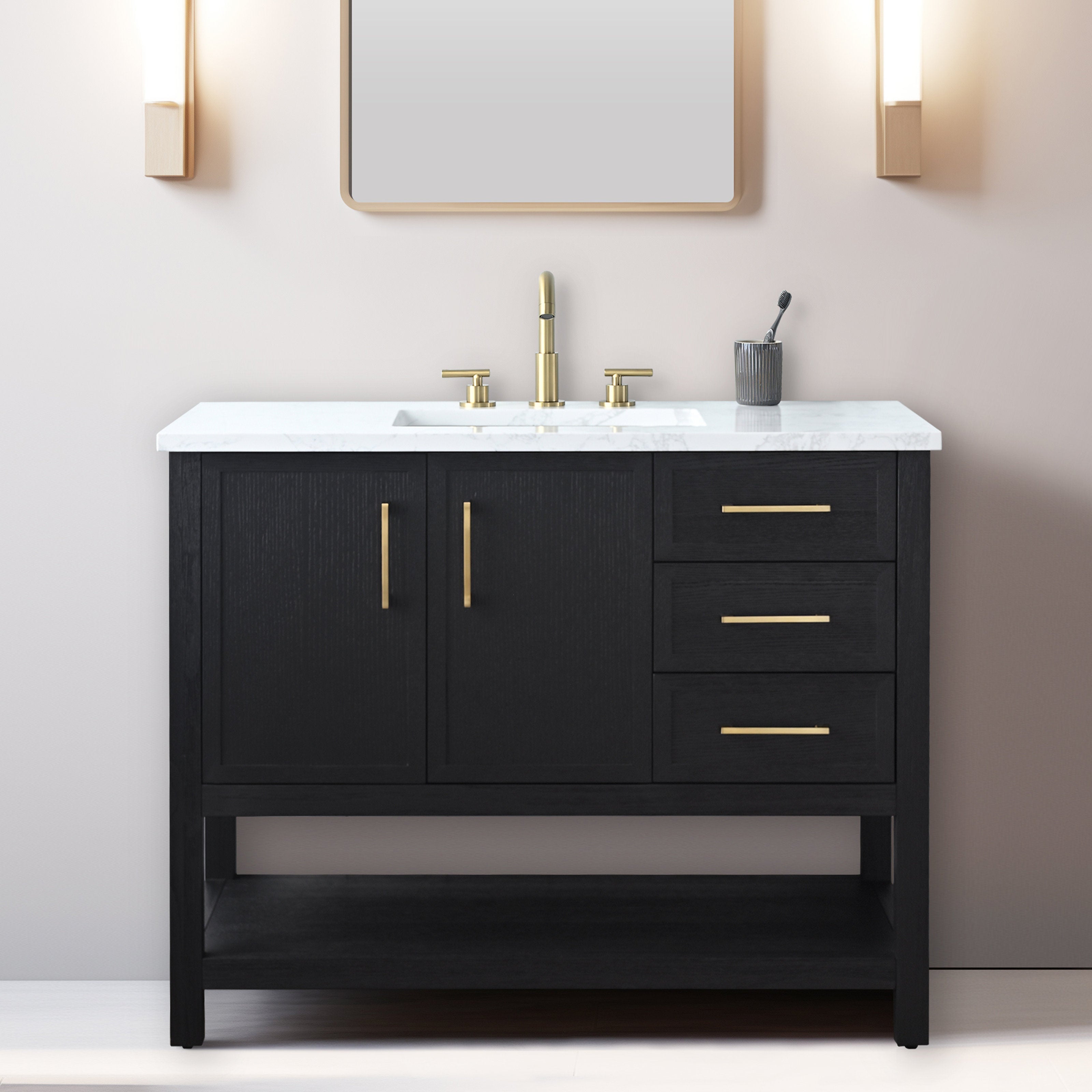 Black solid wood 42-inch freestanding bathroom vanity with white marble stone top, integrated rectangular ceramic sink, brass faucet and hardware, three drawers and open lower shelf against a pale wall.