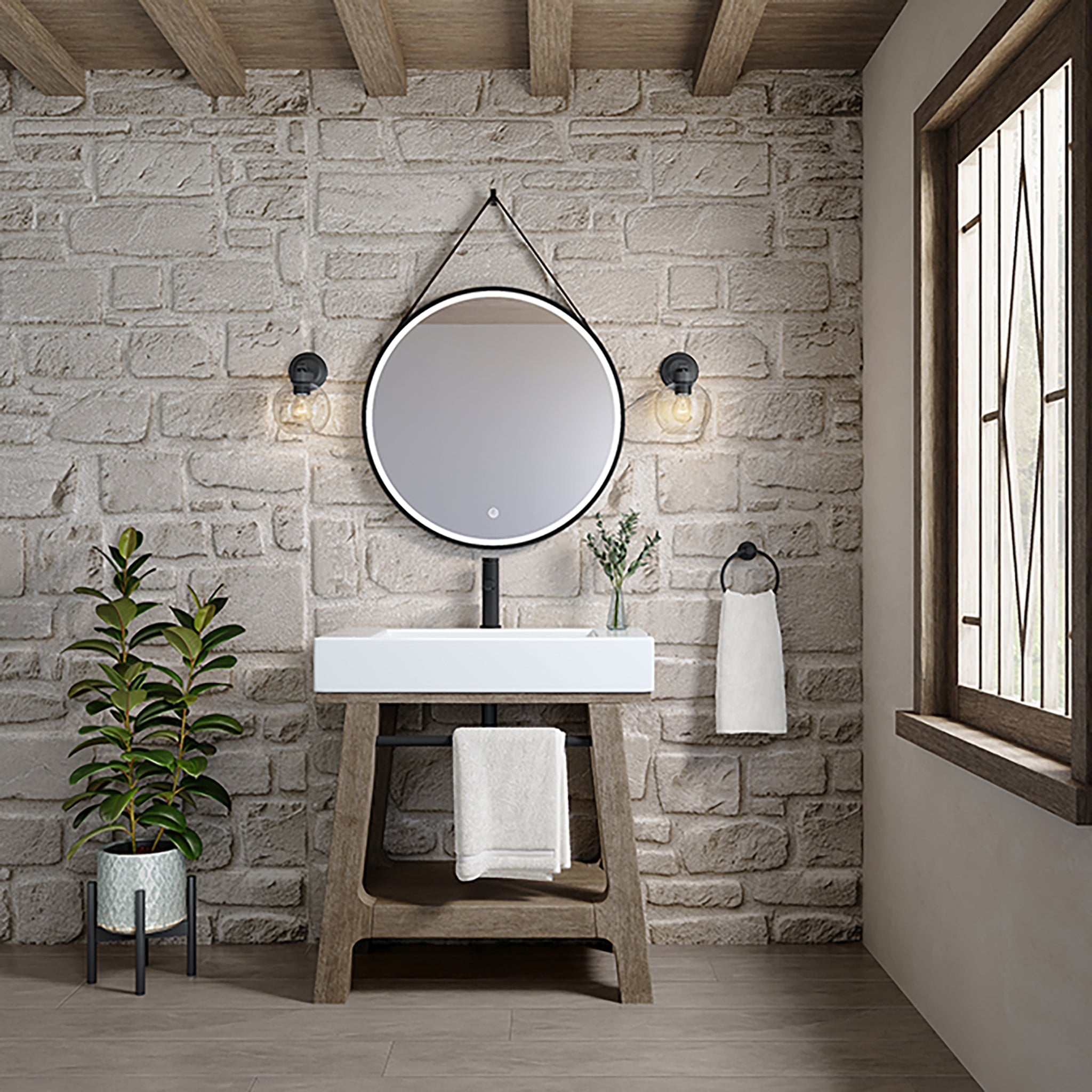 Modern freestanding bathroom vanity with a weathered solid wood base and white glossy composite stone rectangular integrated sink, paired with a round hanging mirror, two wall sconces, towel ring and potted plant against a light stone brick wall.