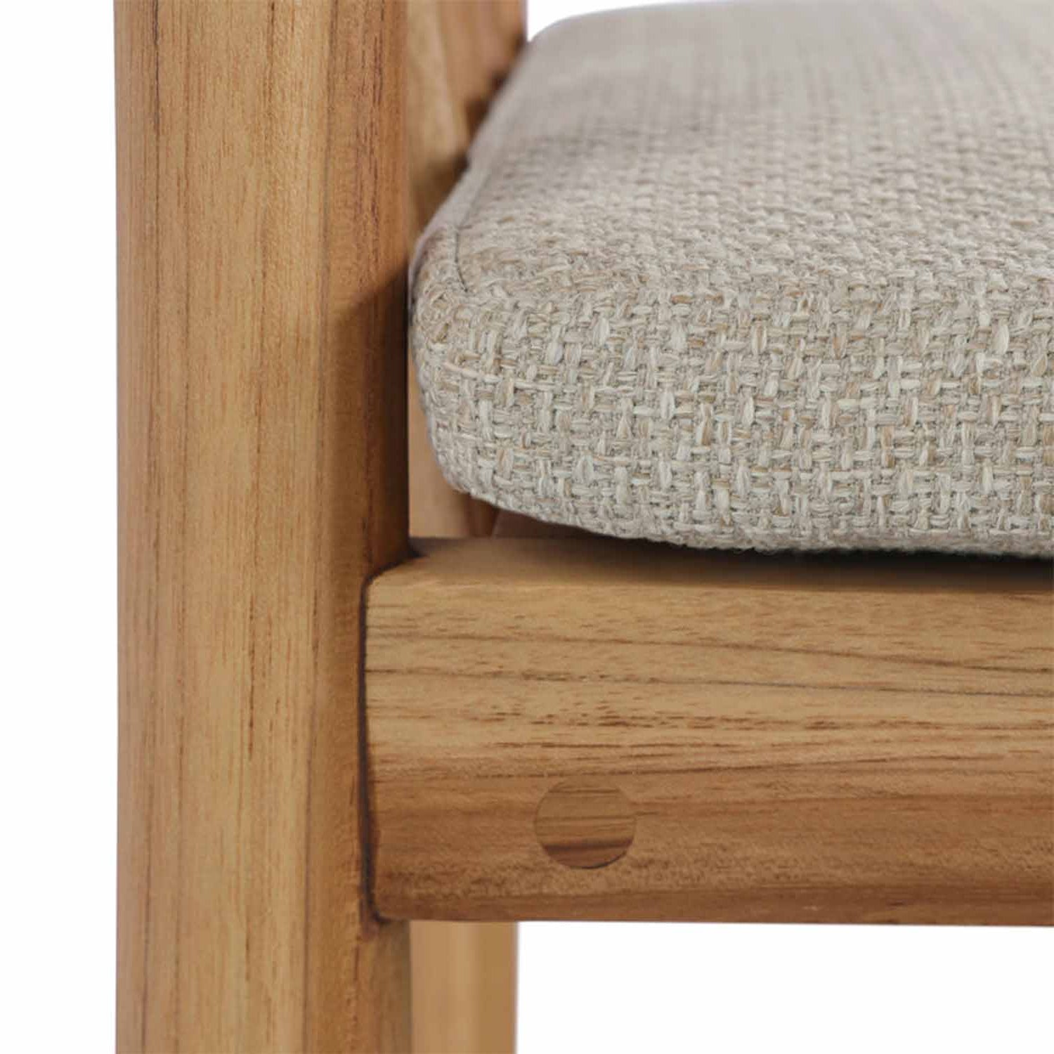 Close-up of a teak outdoor bar stool frame showing natural wood grain, a circular dowel joint and a textured beige upholstered seat cushion.