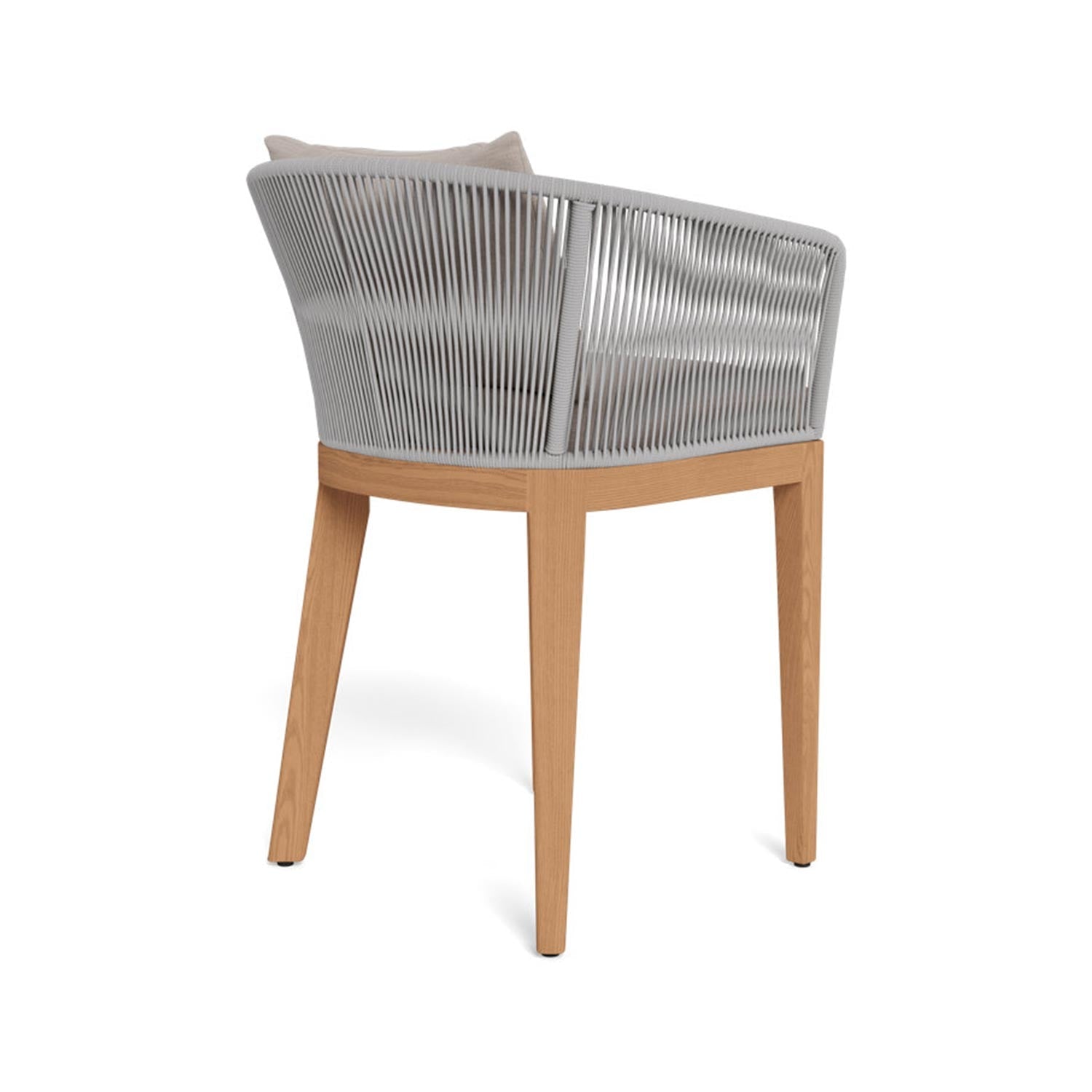 Rear three-quarter view of an outdoor bar stool with tapered teak legs, a curved light-gray rope-wrapped back and a beige upholstered seat cushion with pillow in a coastal contemporary style.